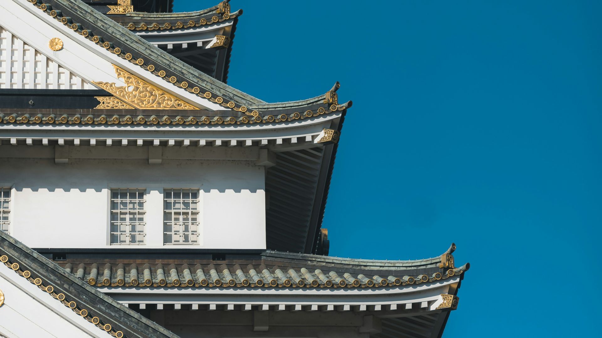 a tall white and gold building with a blue sky in the background