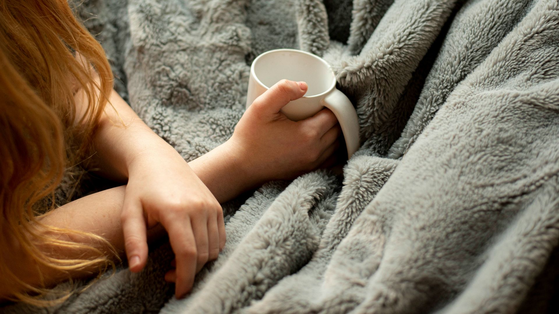 woman holding white ceramic mug