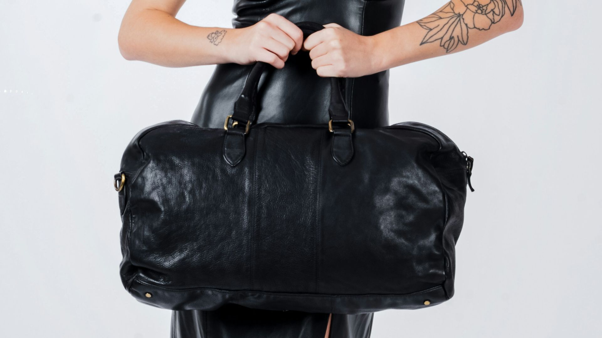 a woman in a black dress holding a black bag