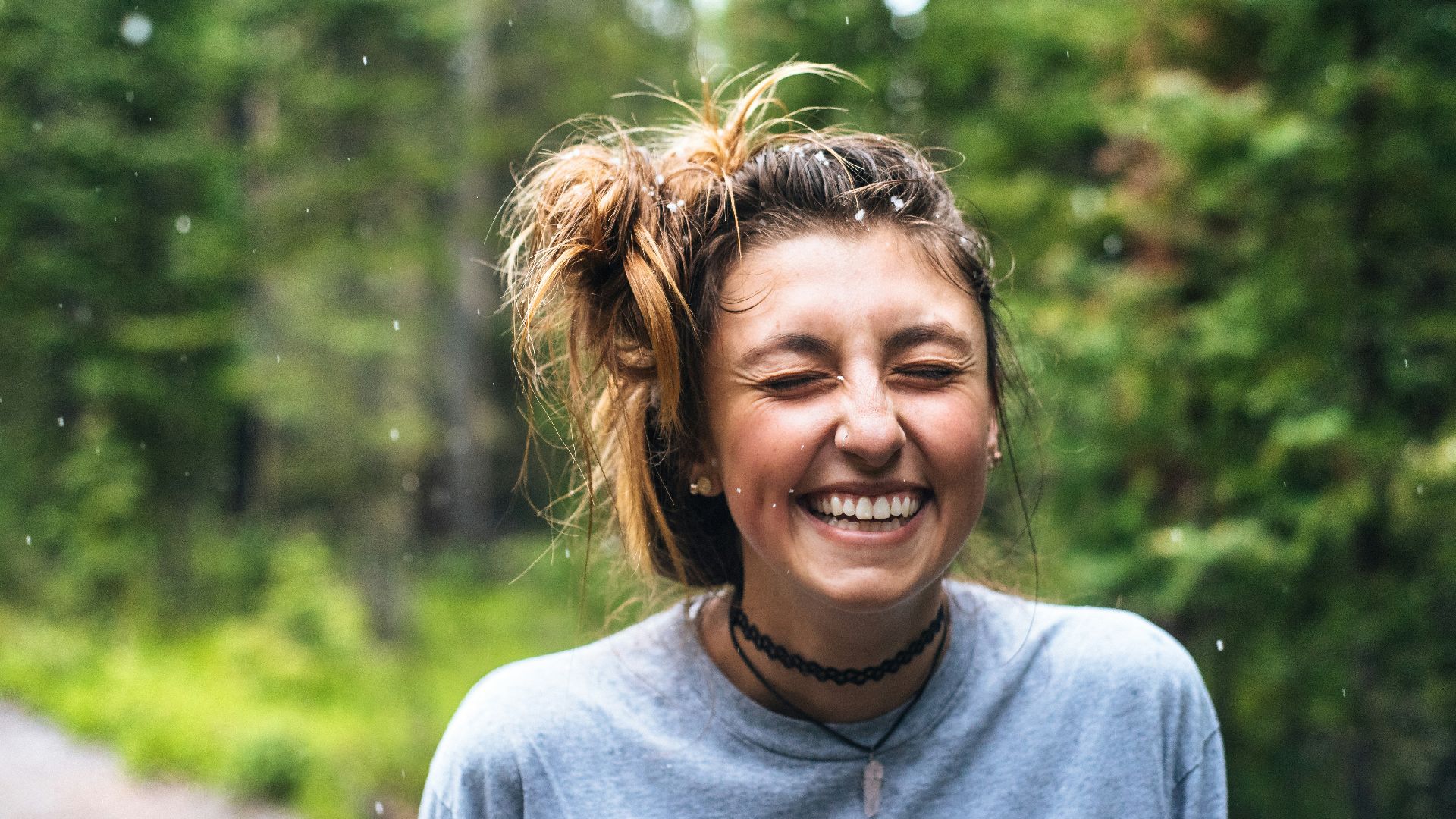 woman smiling near tree outdoor during daytime