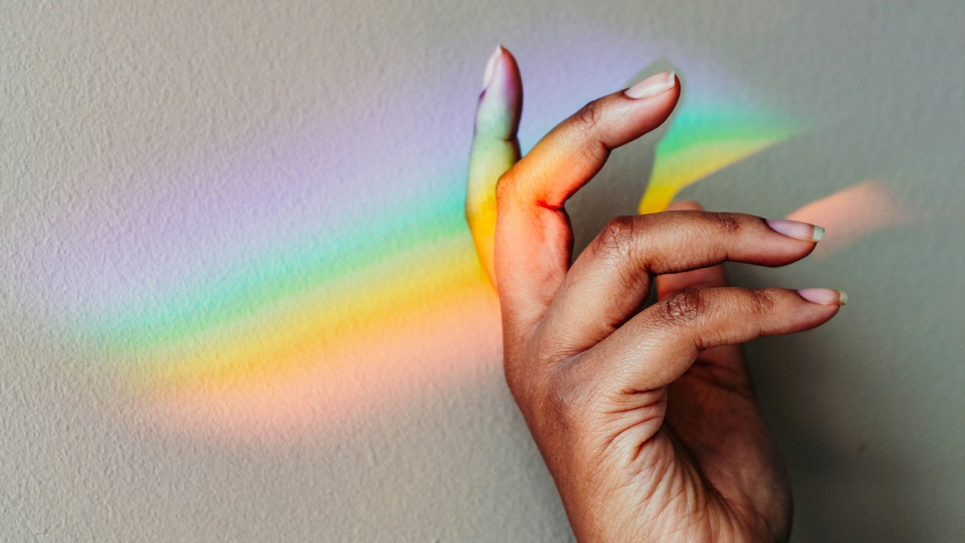 persons hand with green pink and yellow light