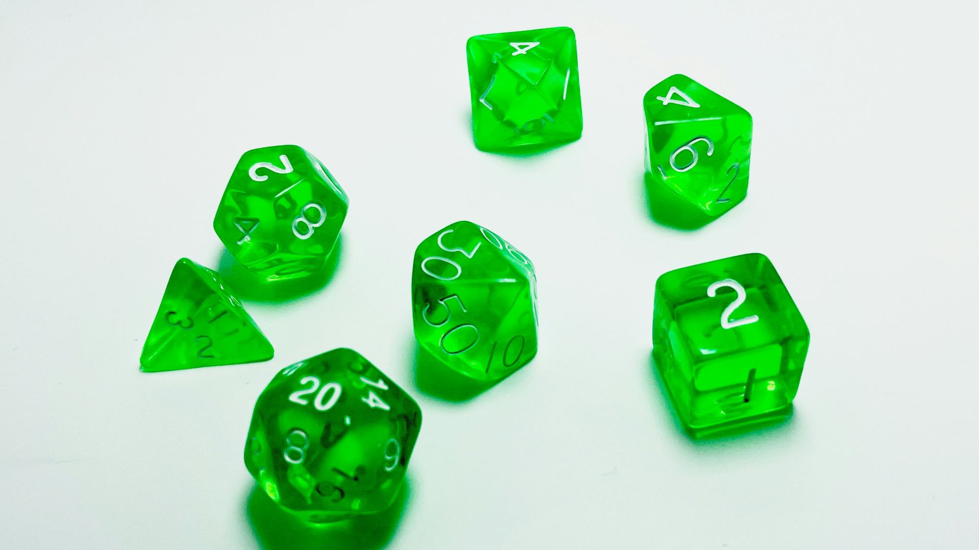 green plastic dice on white surface