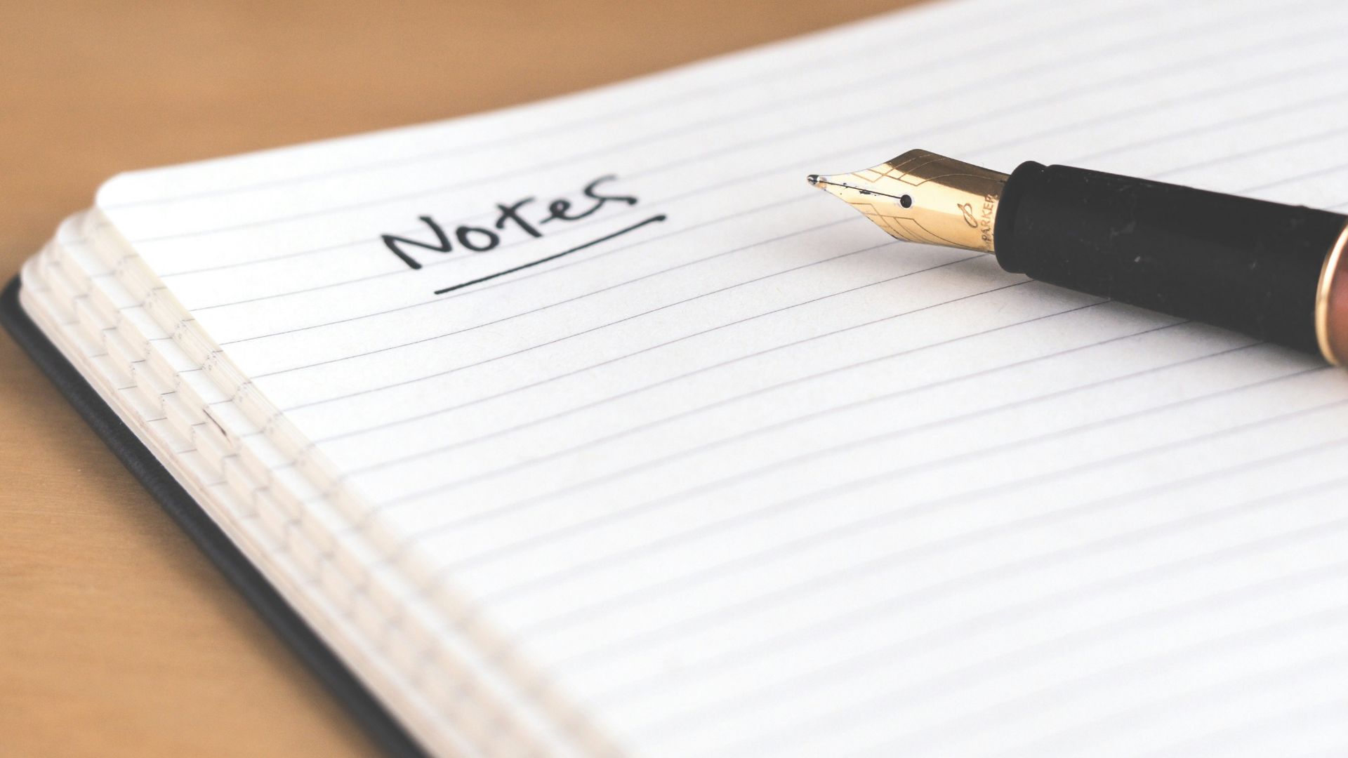 brown fountain pen on notebook