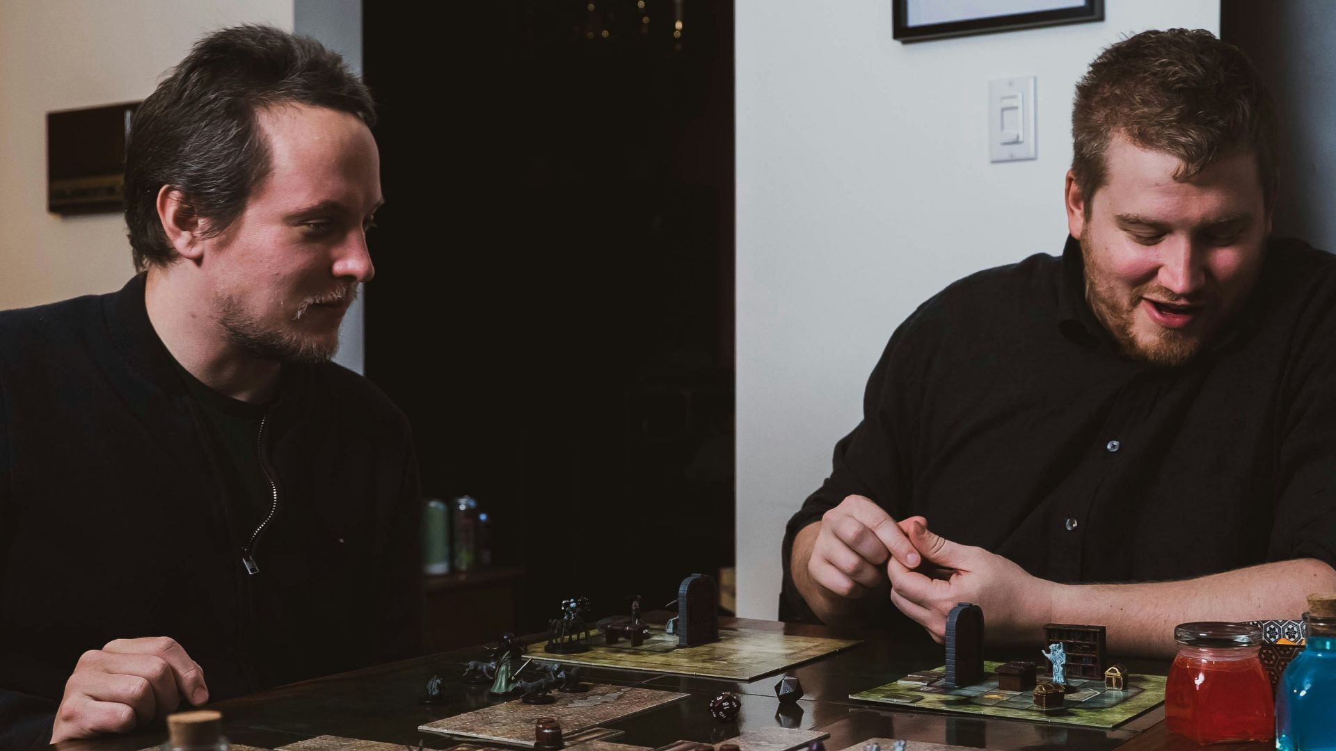 two men sitting at a table playing a board game