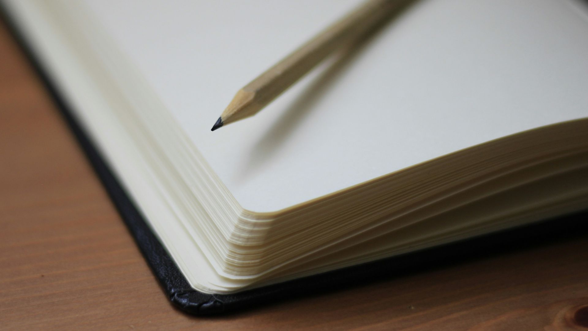 shallow focus photography of pencil on book