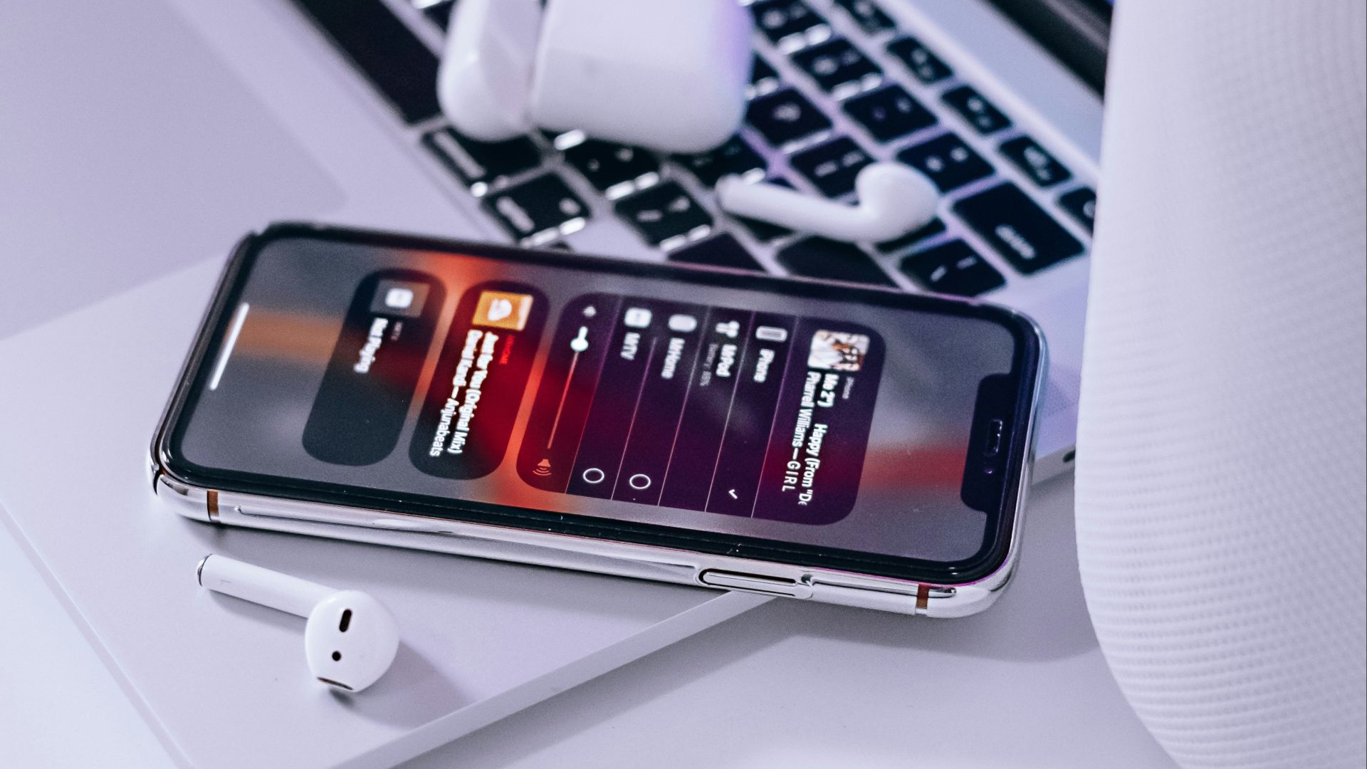 iPhone on Macbook beside magic mouse