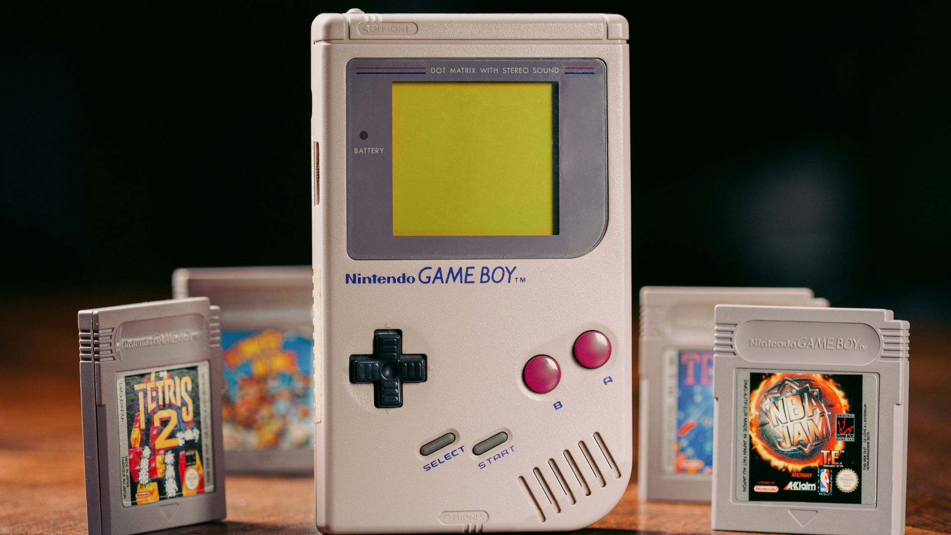 a nintendo game boy sitting on top of a wooden table