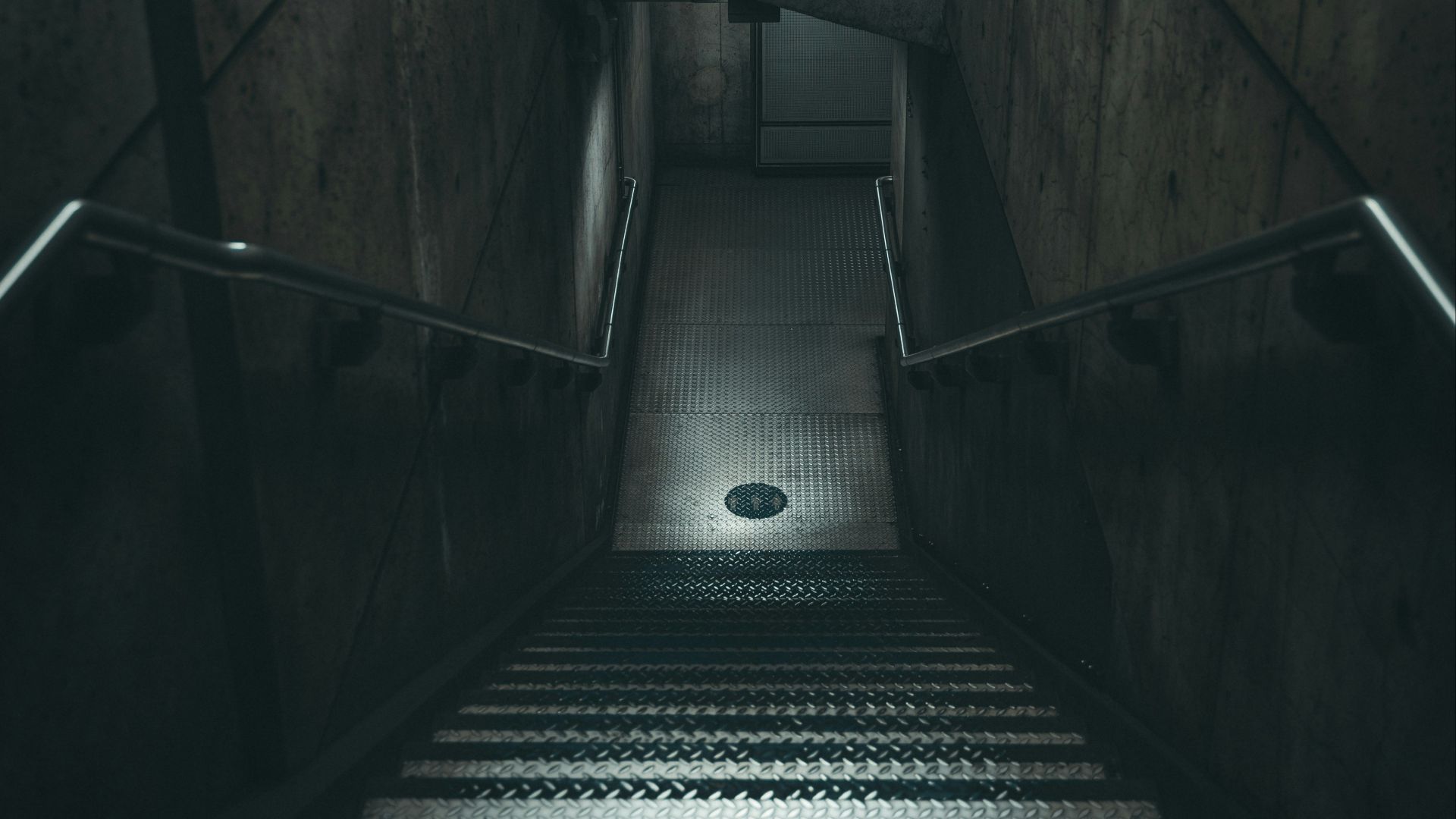 a dark staircase with a light at the end