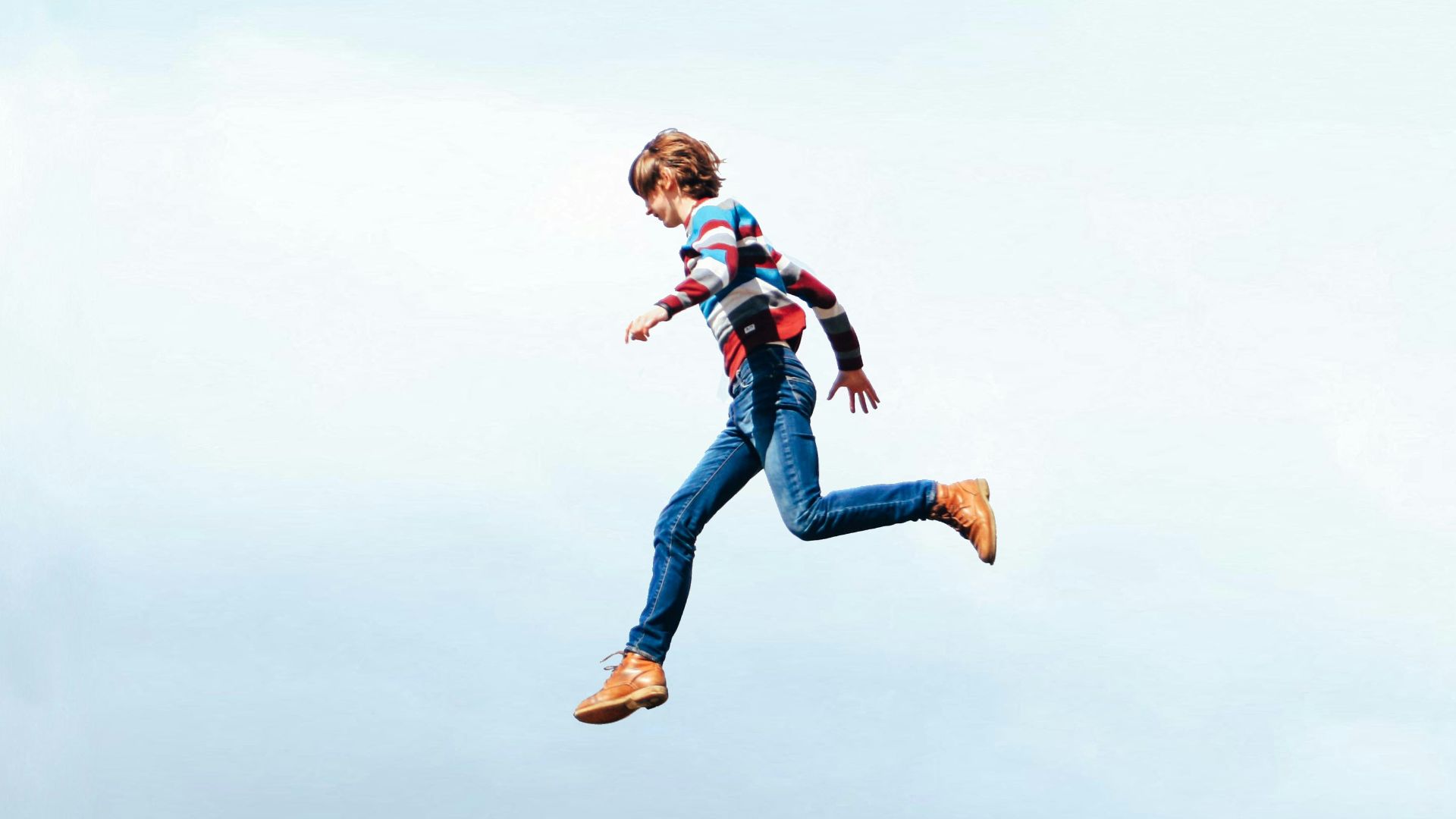 a woman flying through the air while holding onto a kite