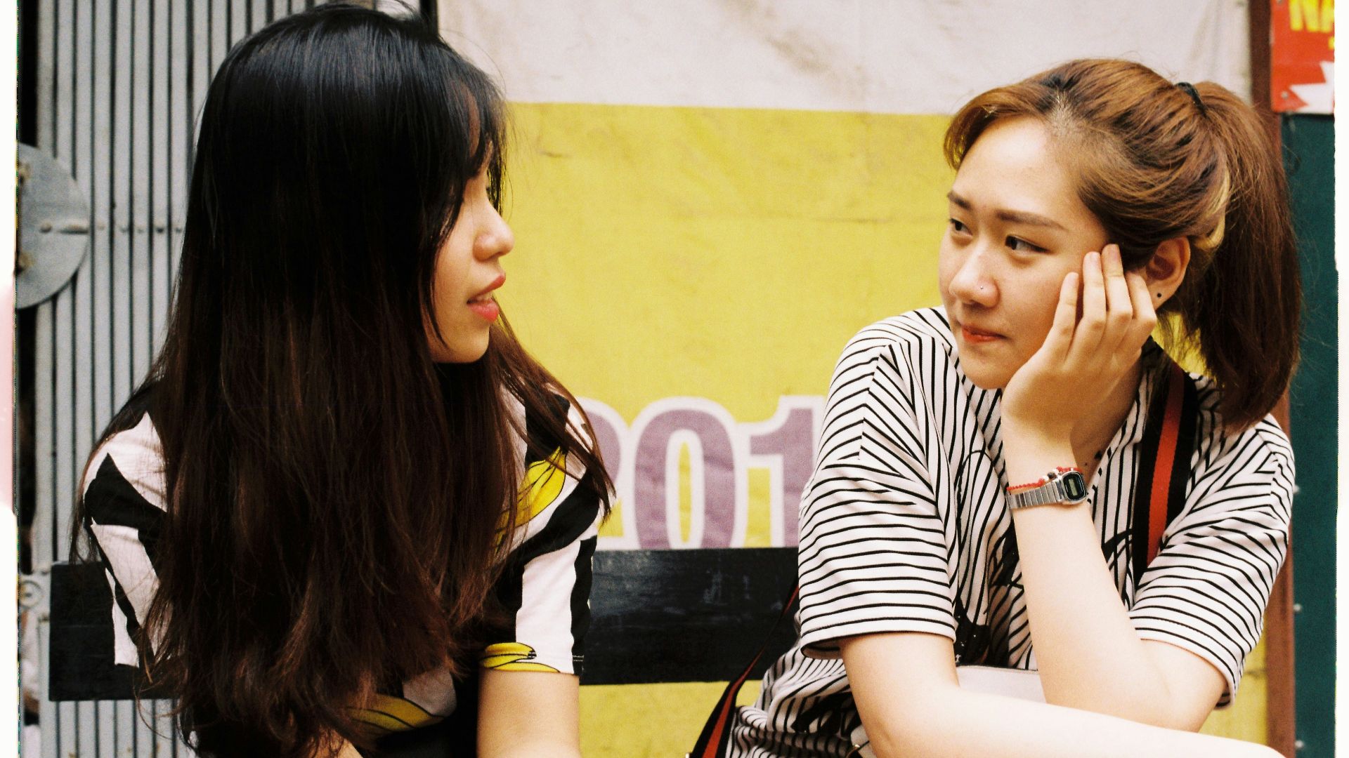 woman in white-and-black striped tops looking each other