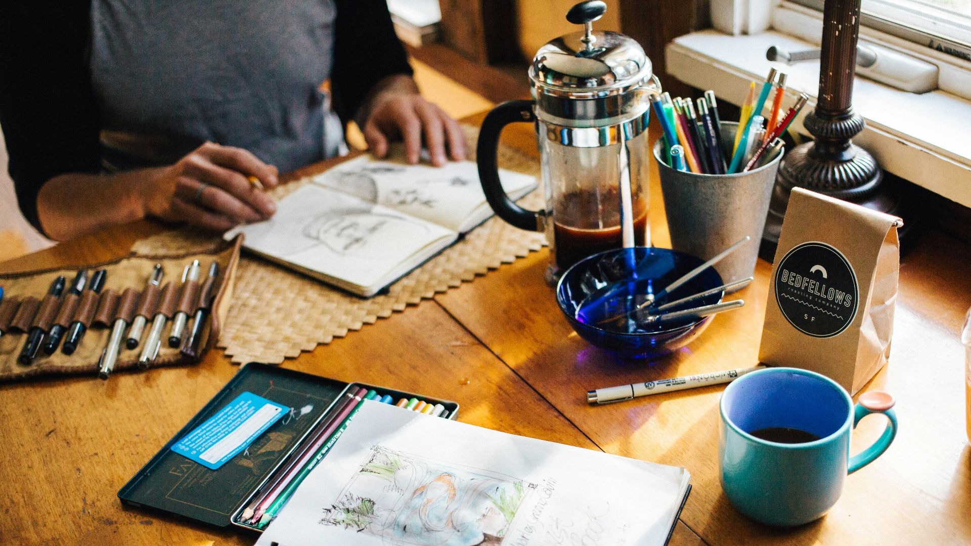 person holding book with sketch