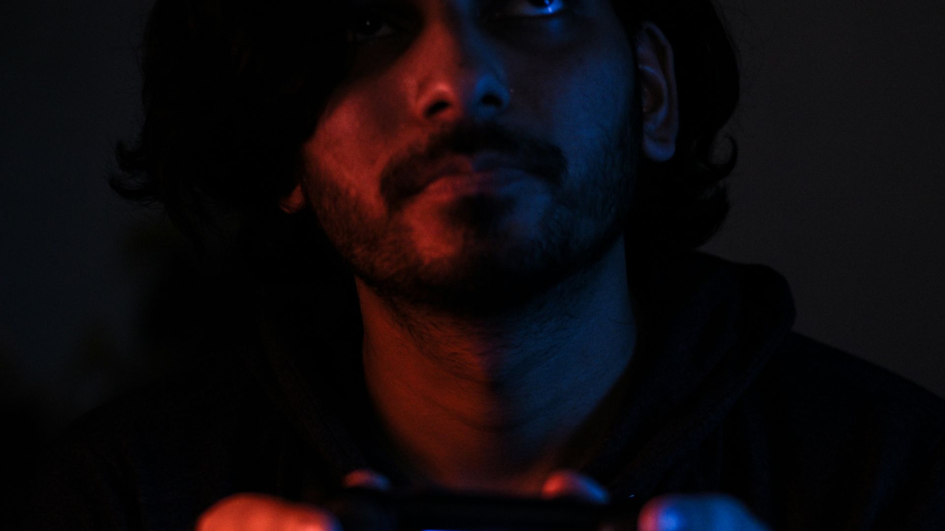 man in black jacket holding black smartphone