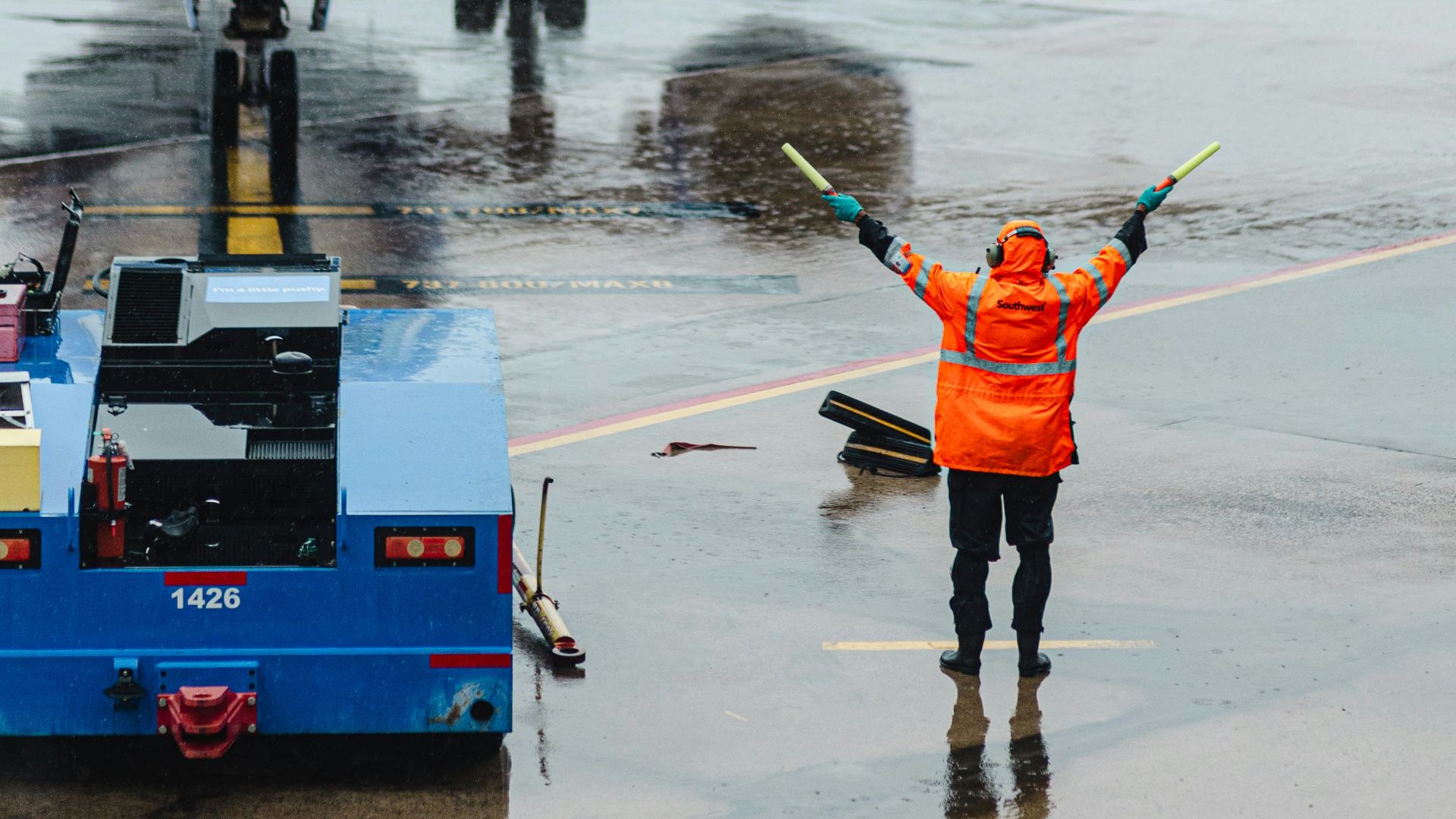 A ground crew directs a plane on the tarmac.