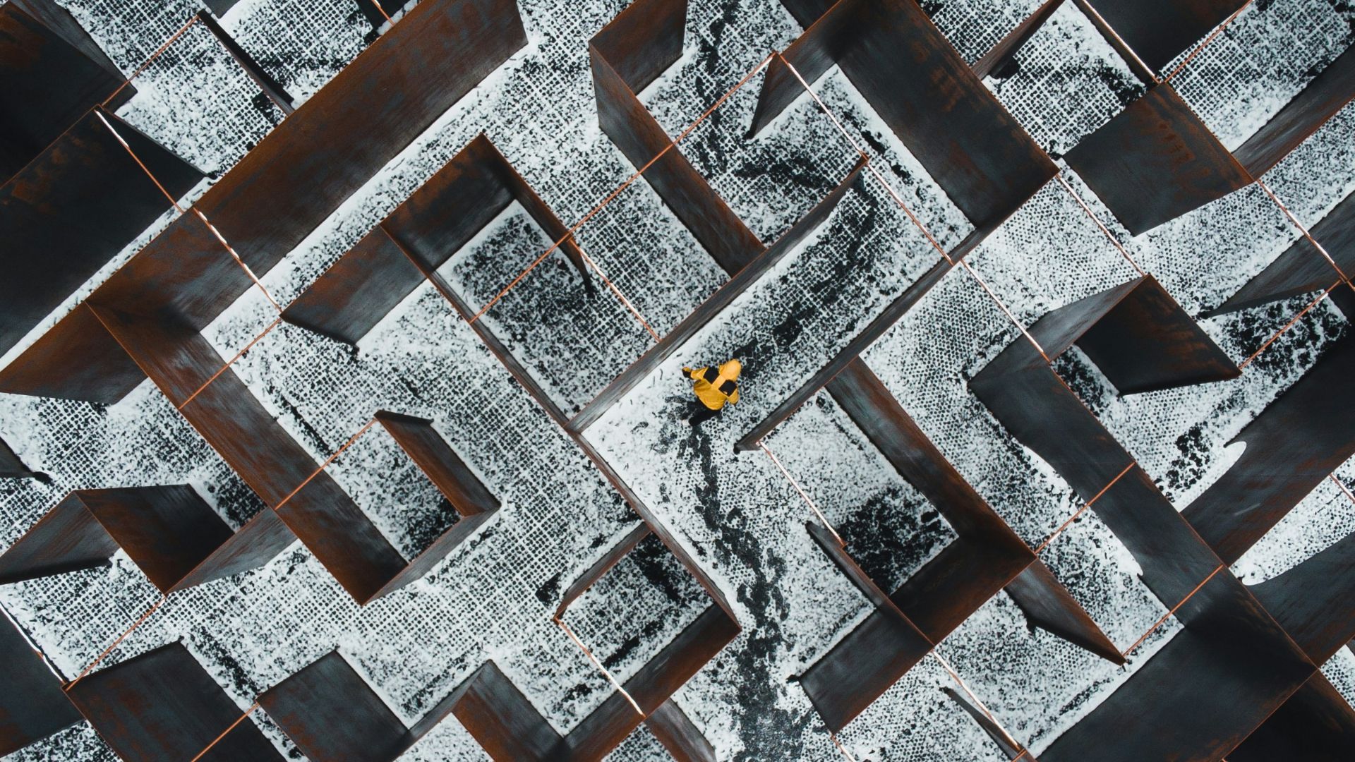 person in black pants walking on black and white concrete blocks