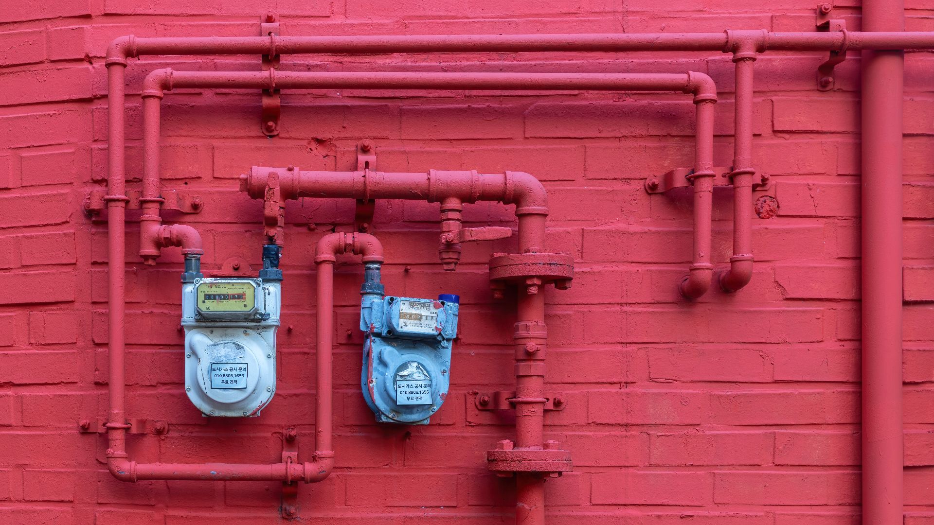 File:Two blue water meters on a matte red painted brick facade with pipes in Seoul.jpg