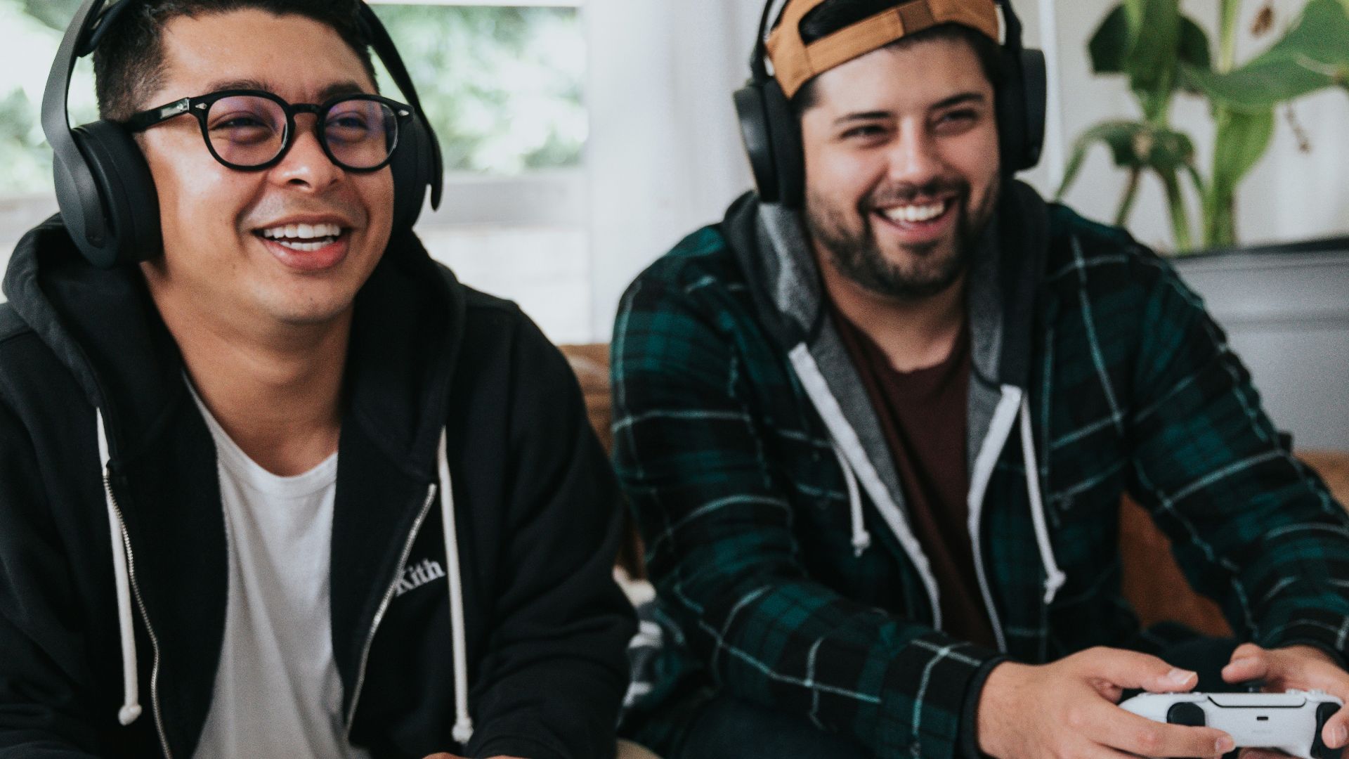 a couple of men sitting at a table with game controllers