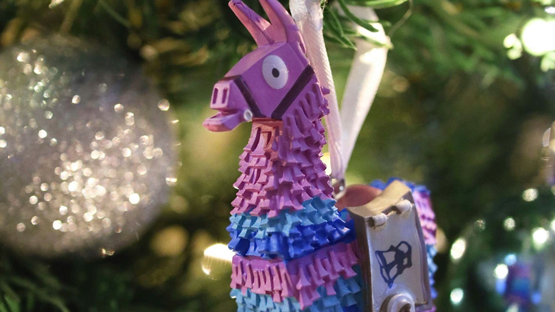 a colorful llama ornament hanging from a christmas tree