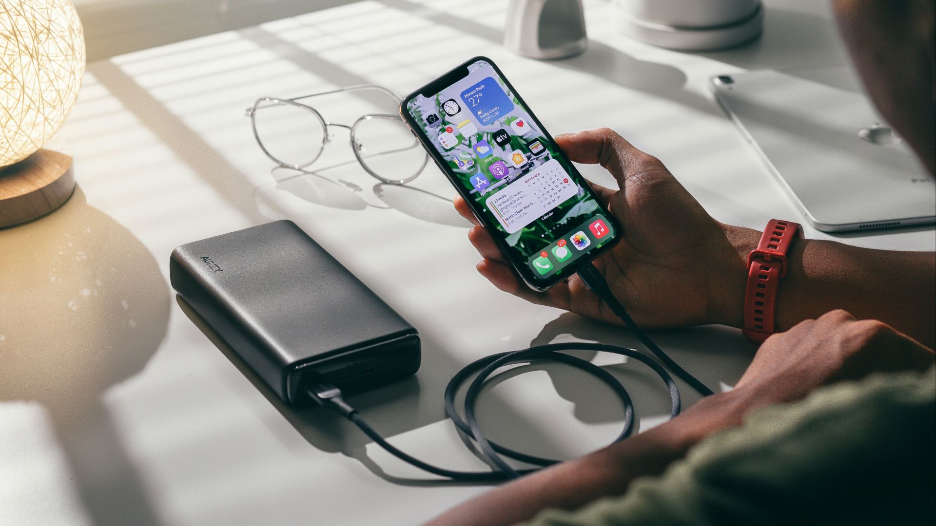 person holding black smartphone on white textile