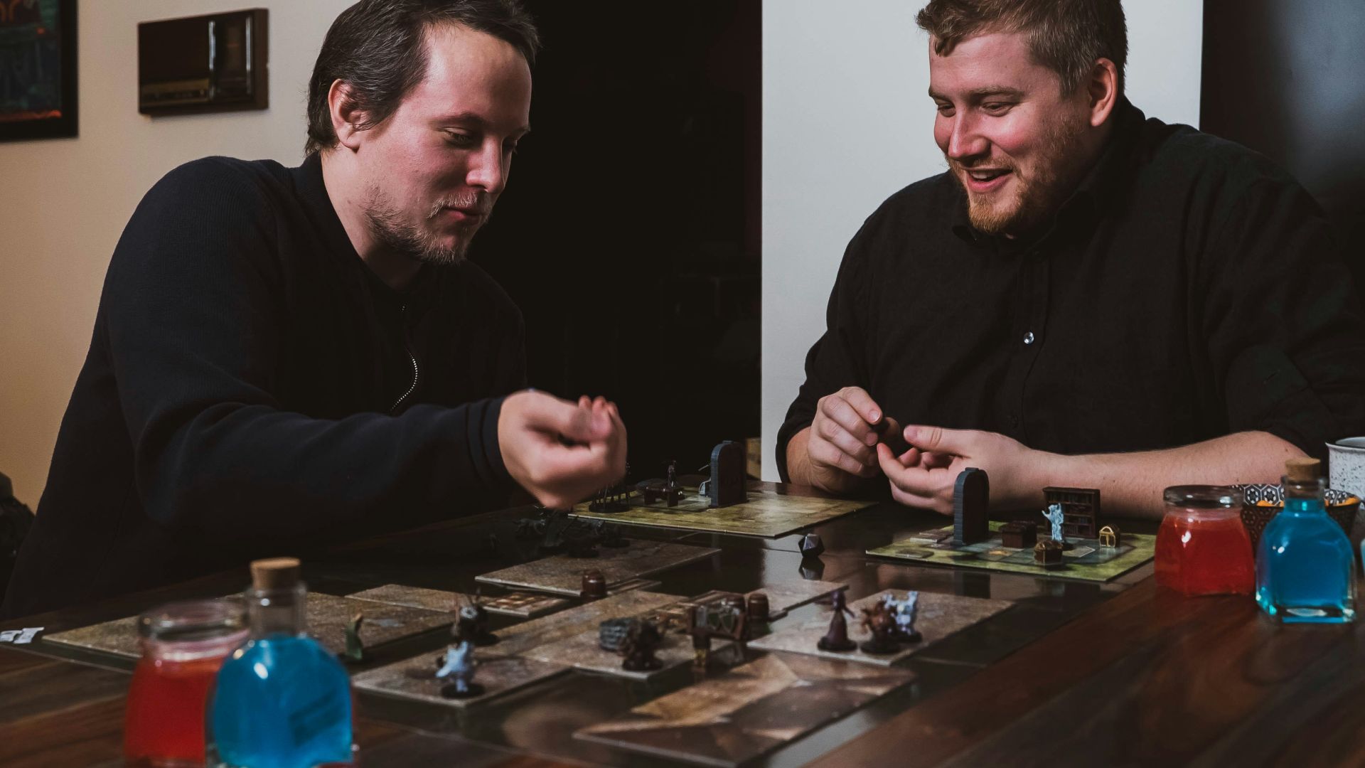 two men sitting at a table playing a board game
