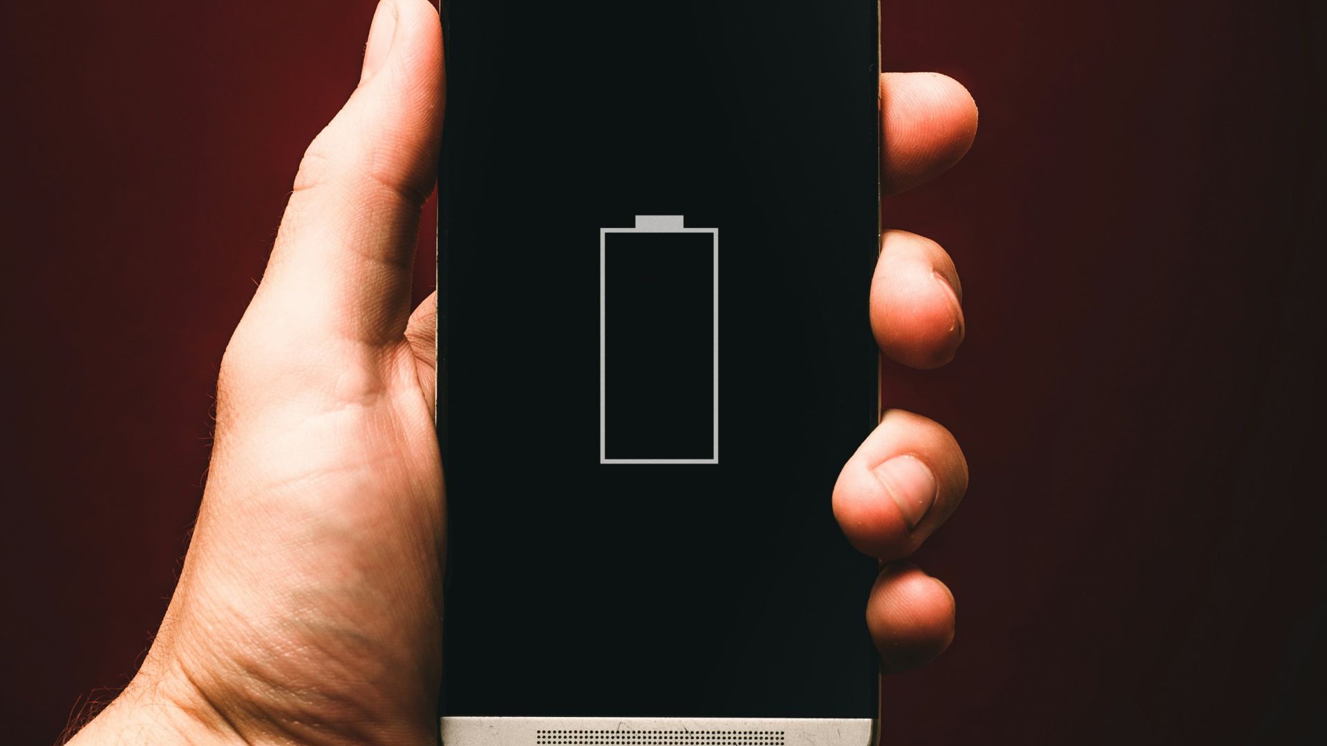 person holding low battery smartphone