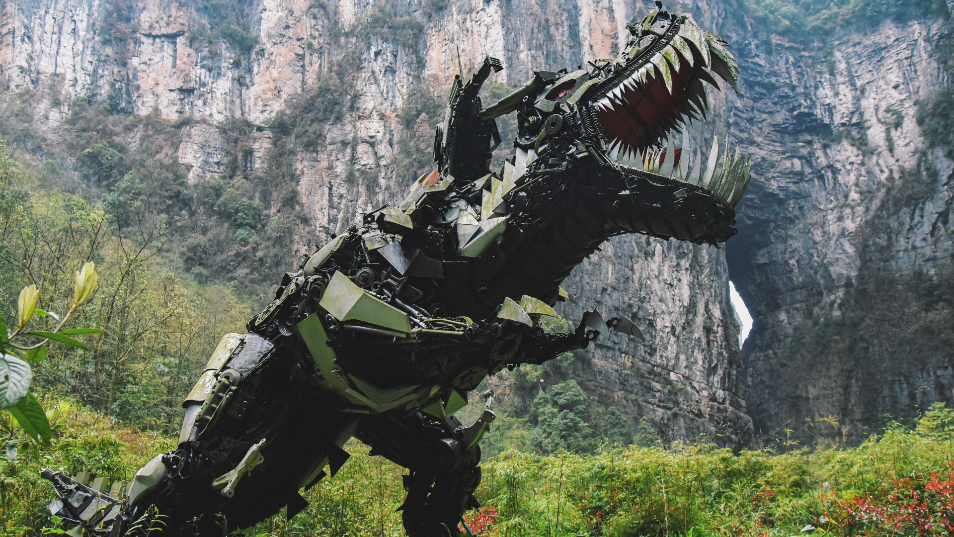 a large dinosaur statue in the middle of a mountain