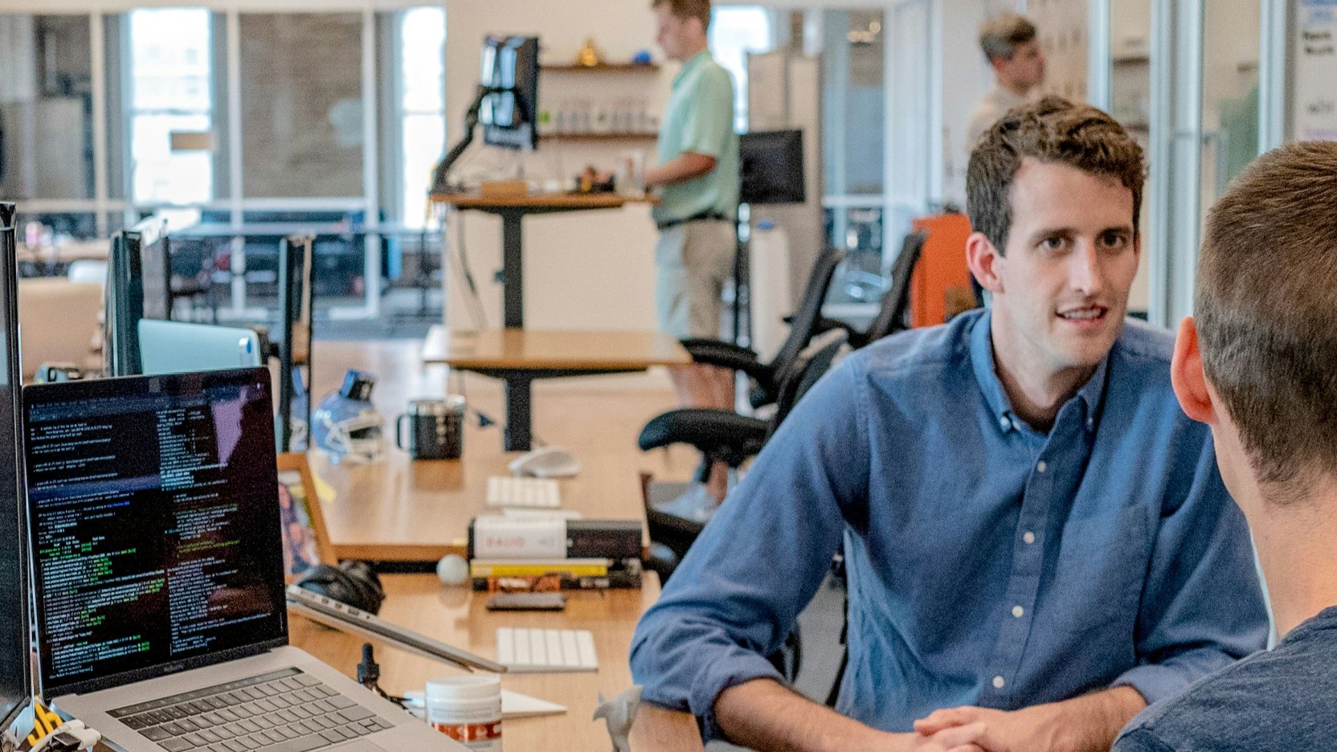 three men sitting on chair beside tables