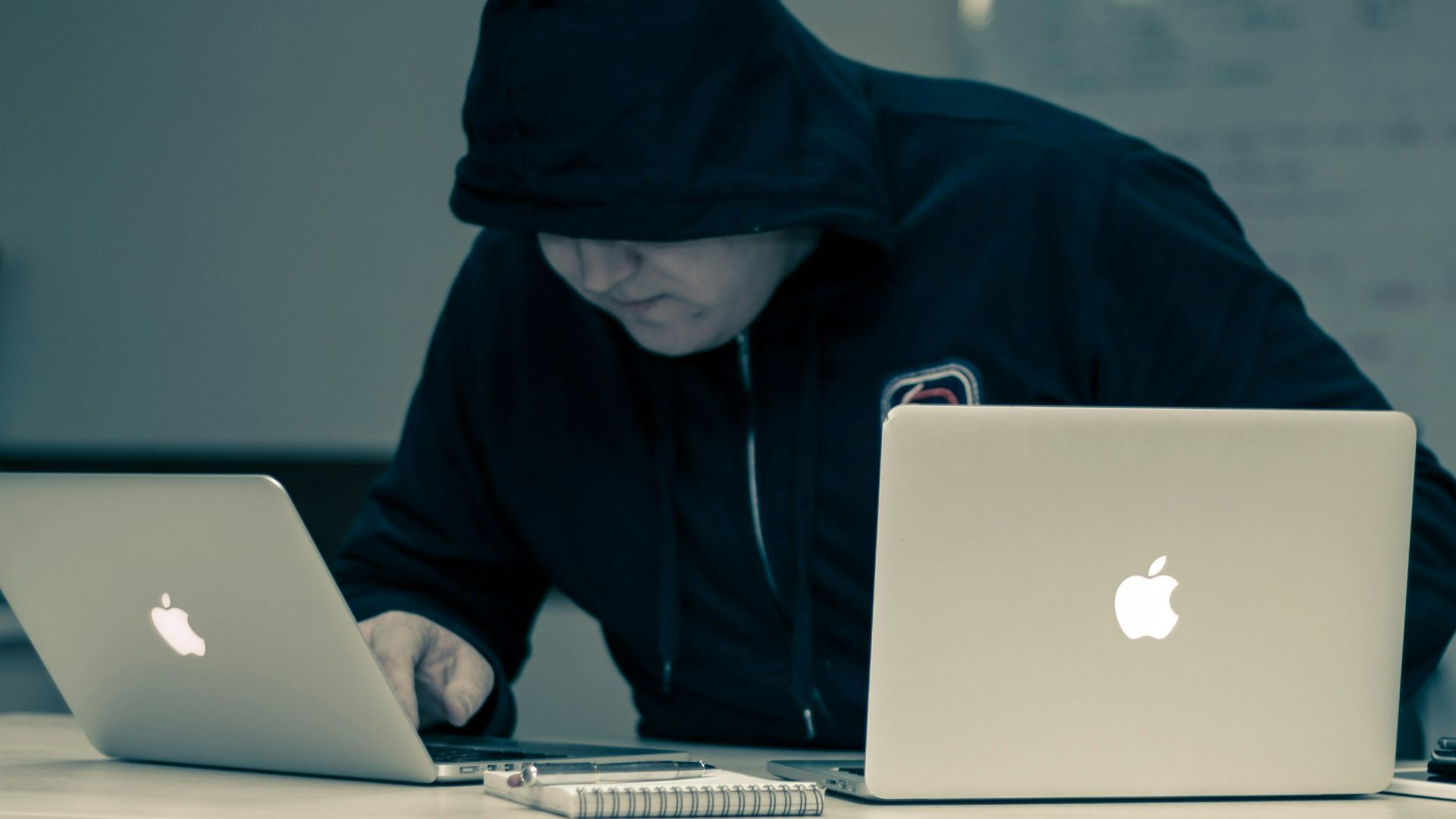 man in black hoodie using macbook