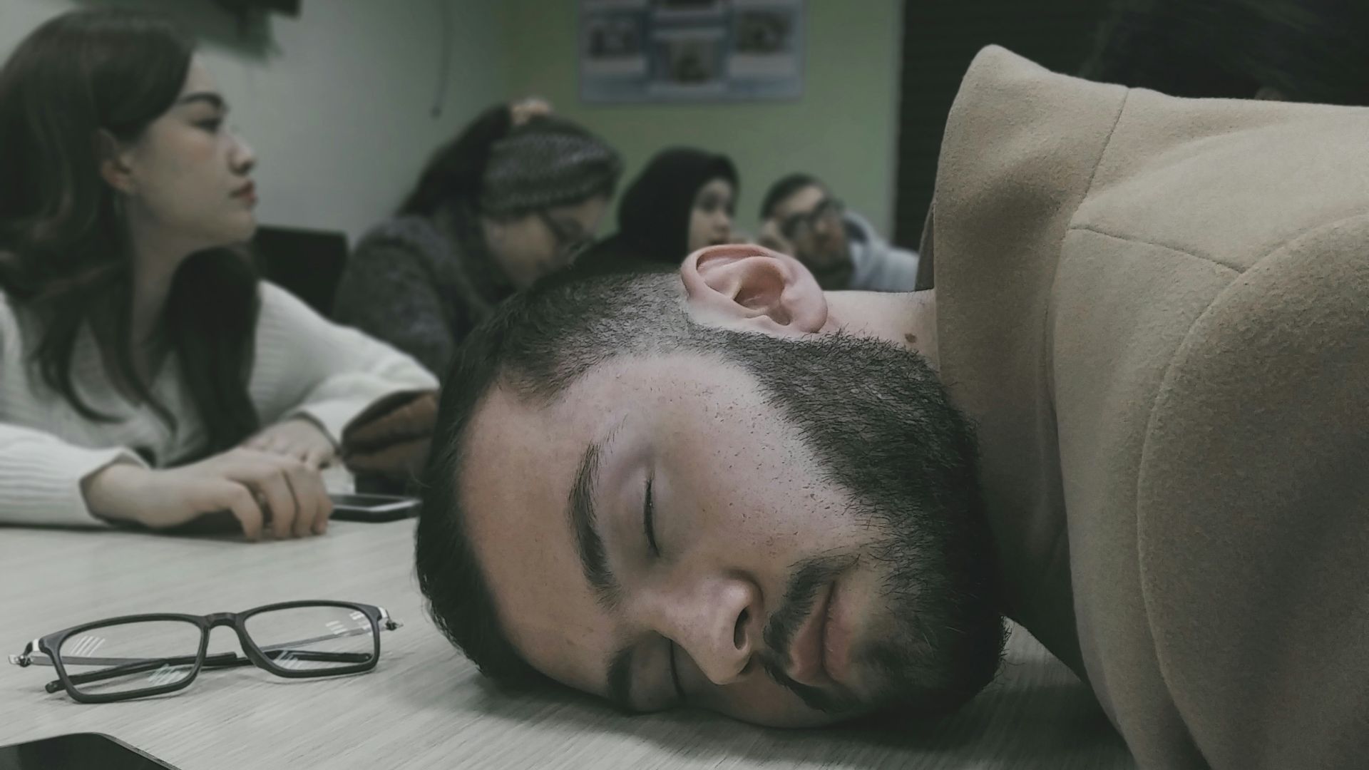a man laying on a table with his head on the table