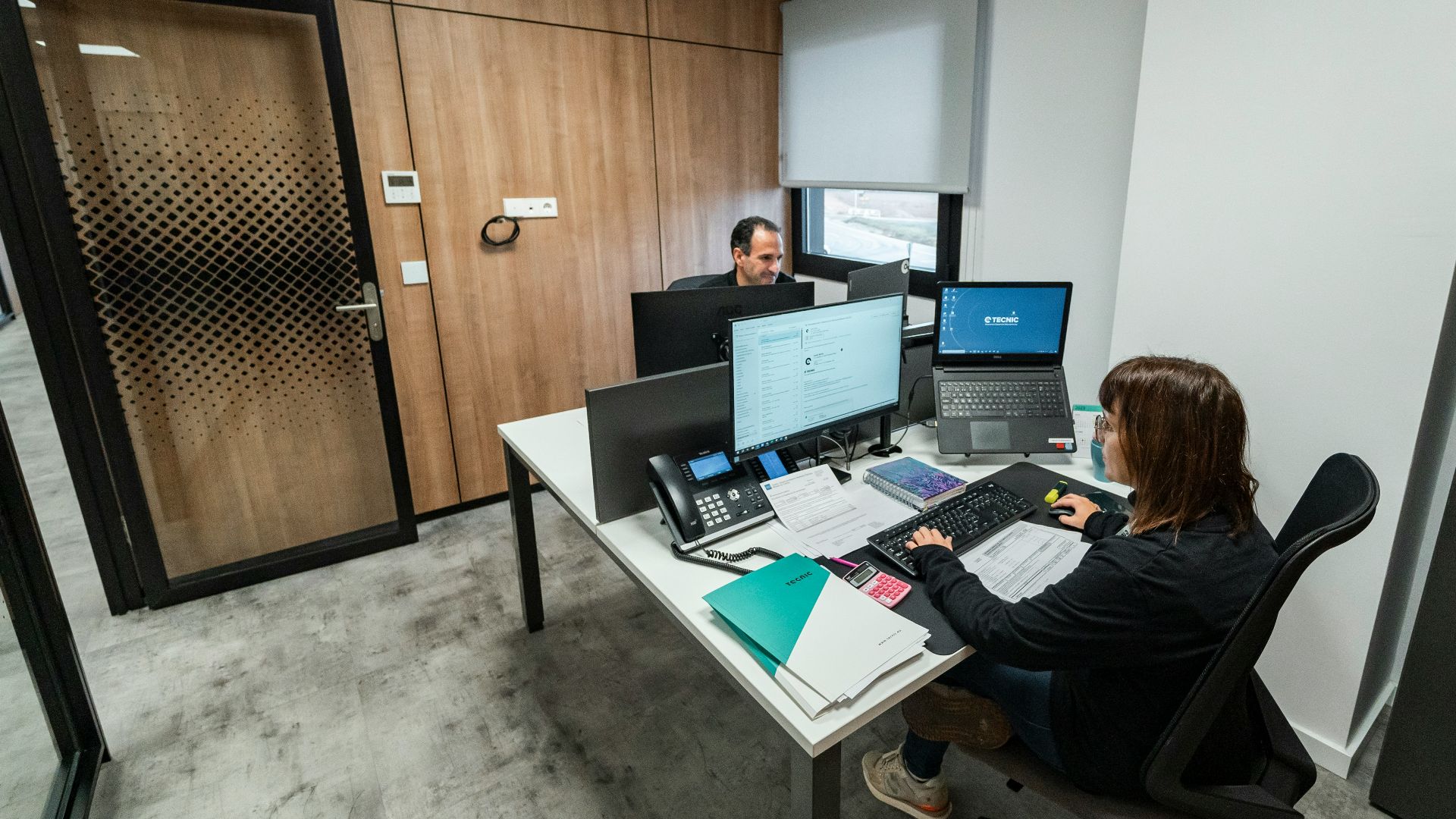 People work at desks in a modern office.