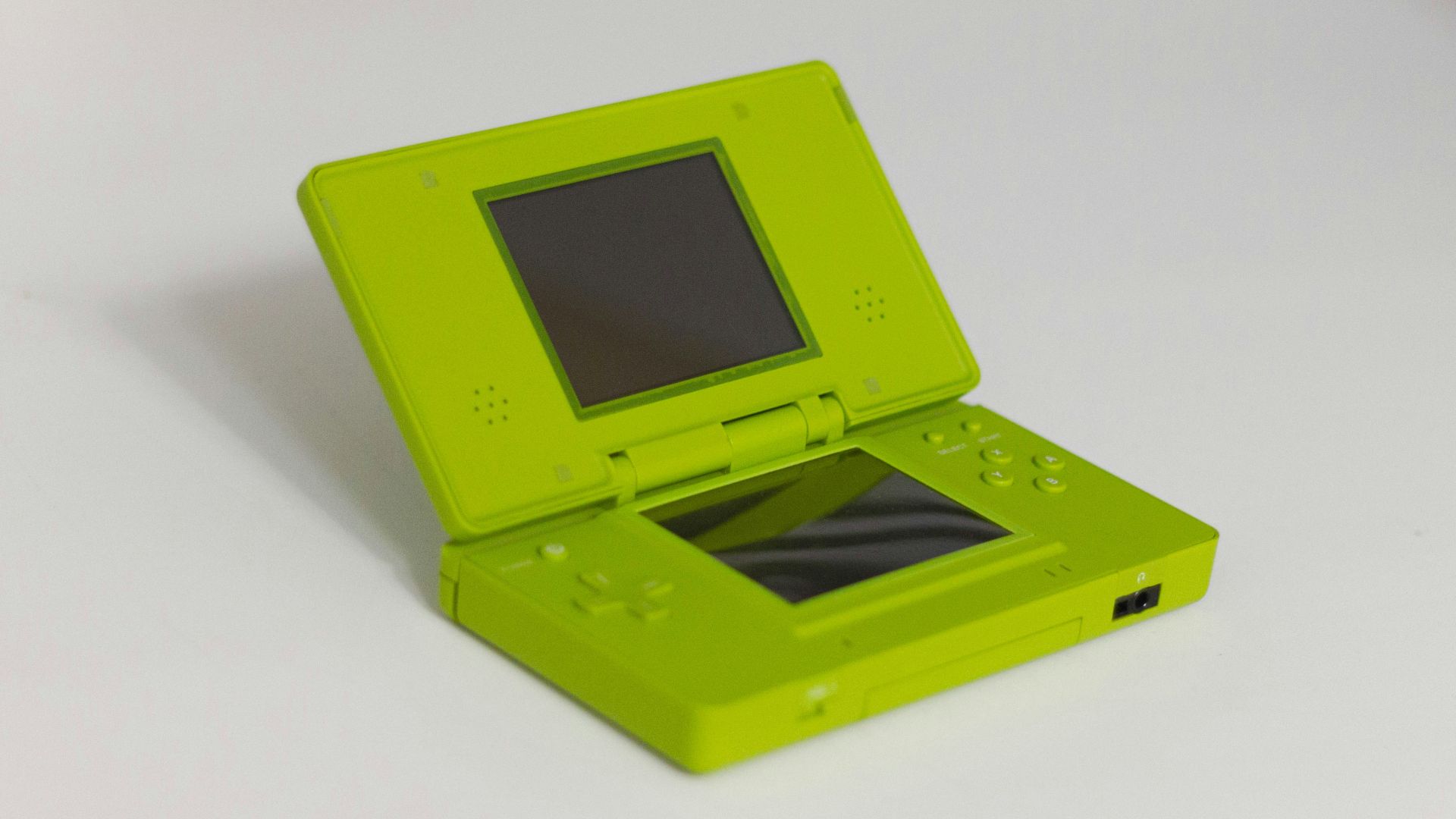 A lime green nintendo ds is displayed open.