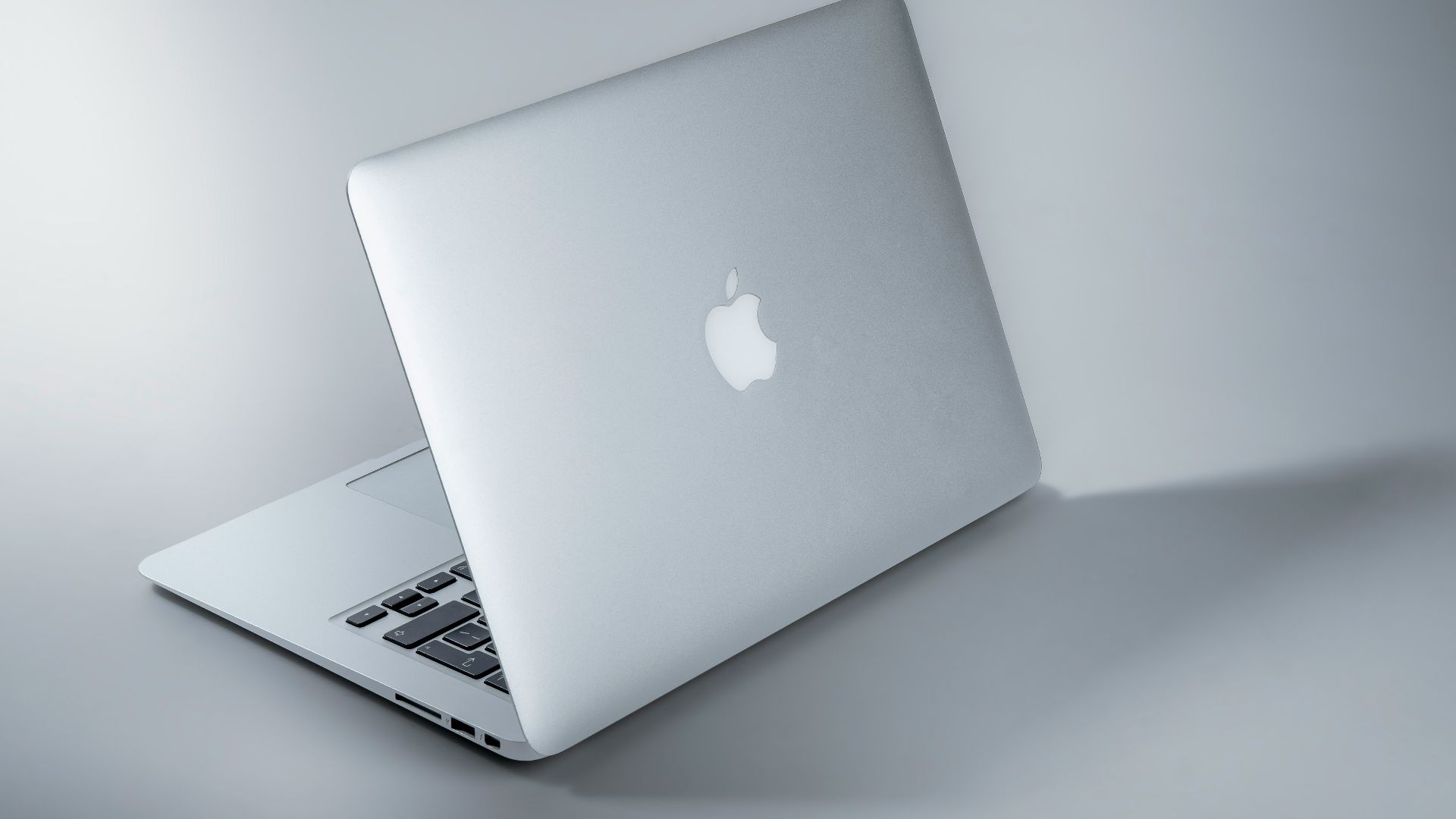 silver macbook on white table