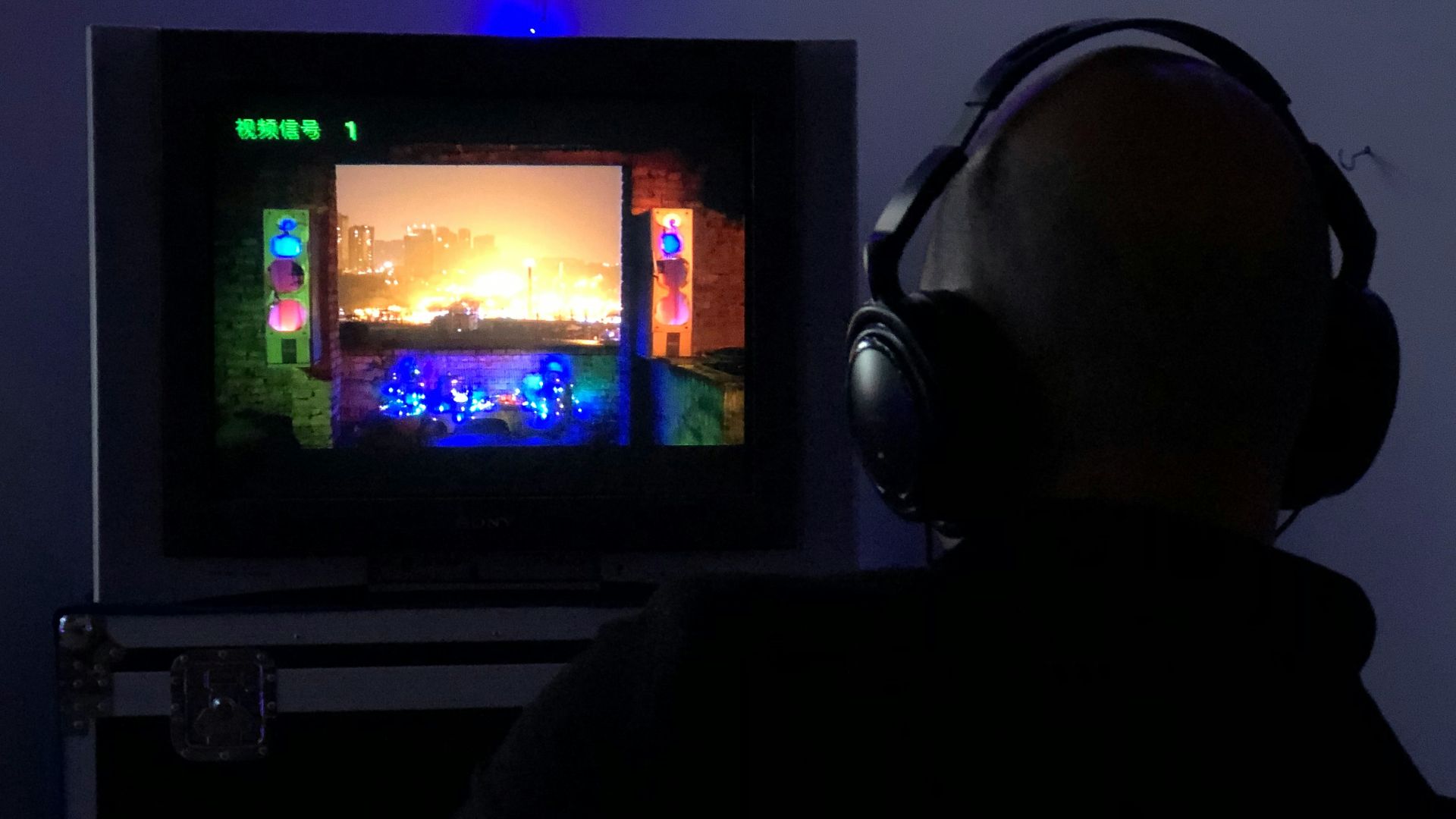 a man sitting in front of a tv with headphones on