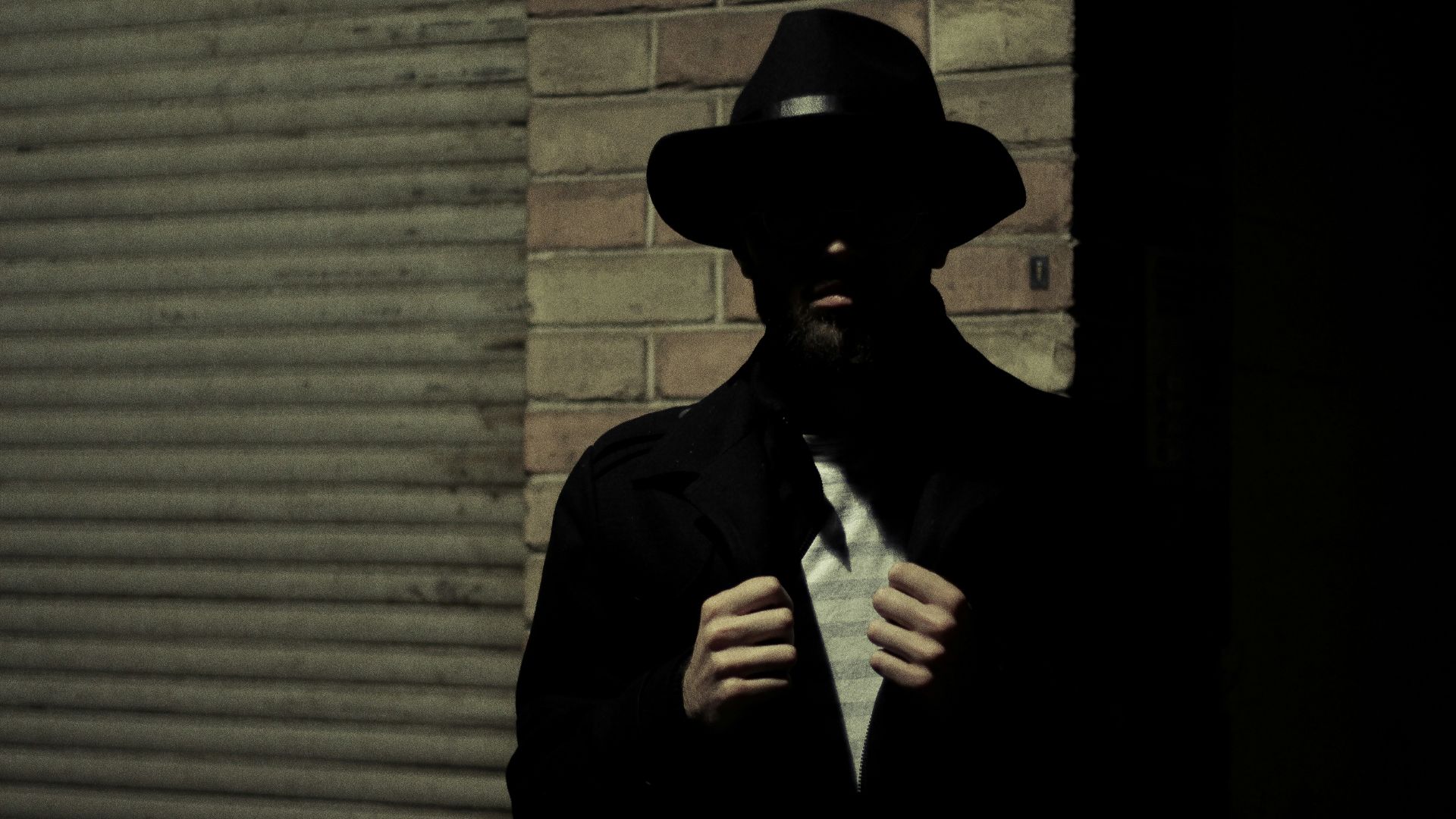 man wearing black fedora hat and black suit jacket