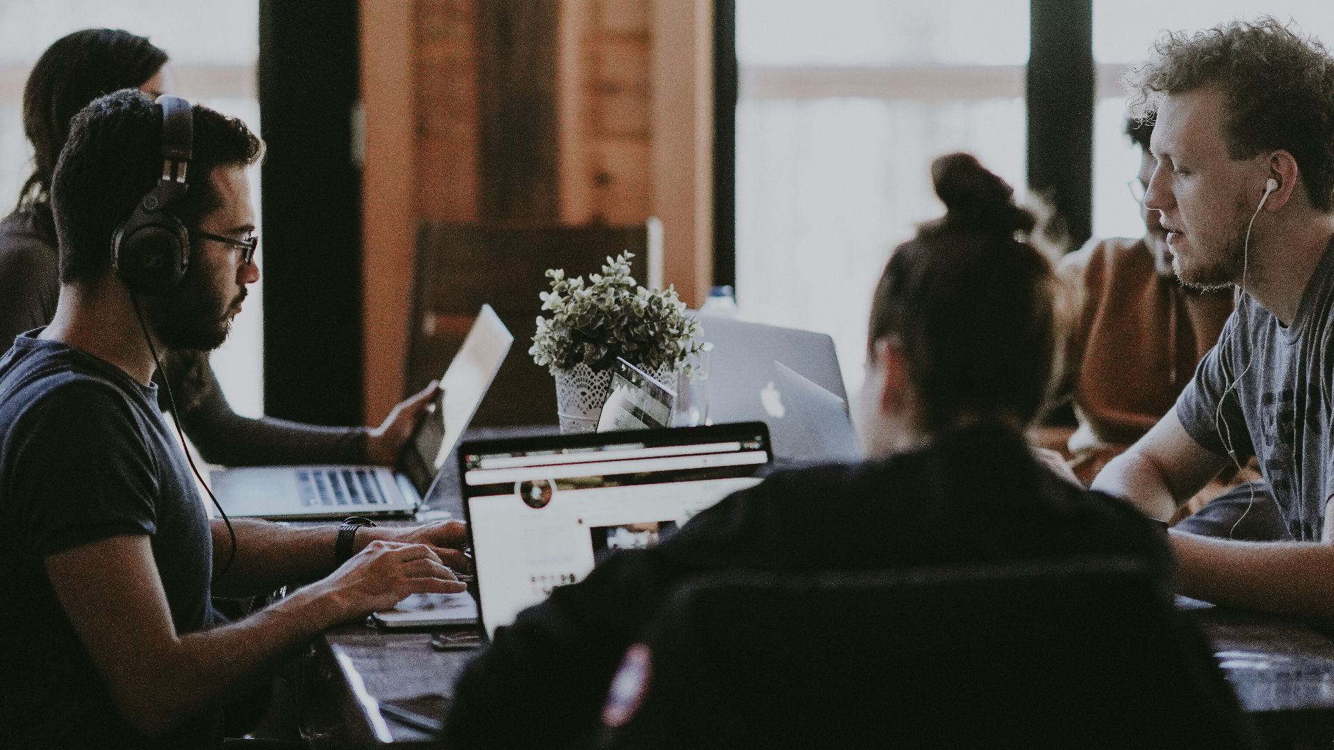 selective focus photography of people sits in front of table inside room