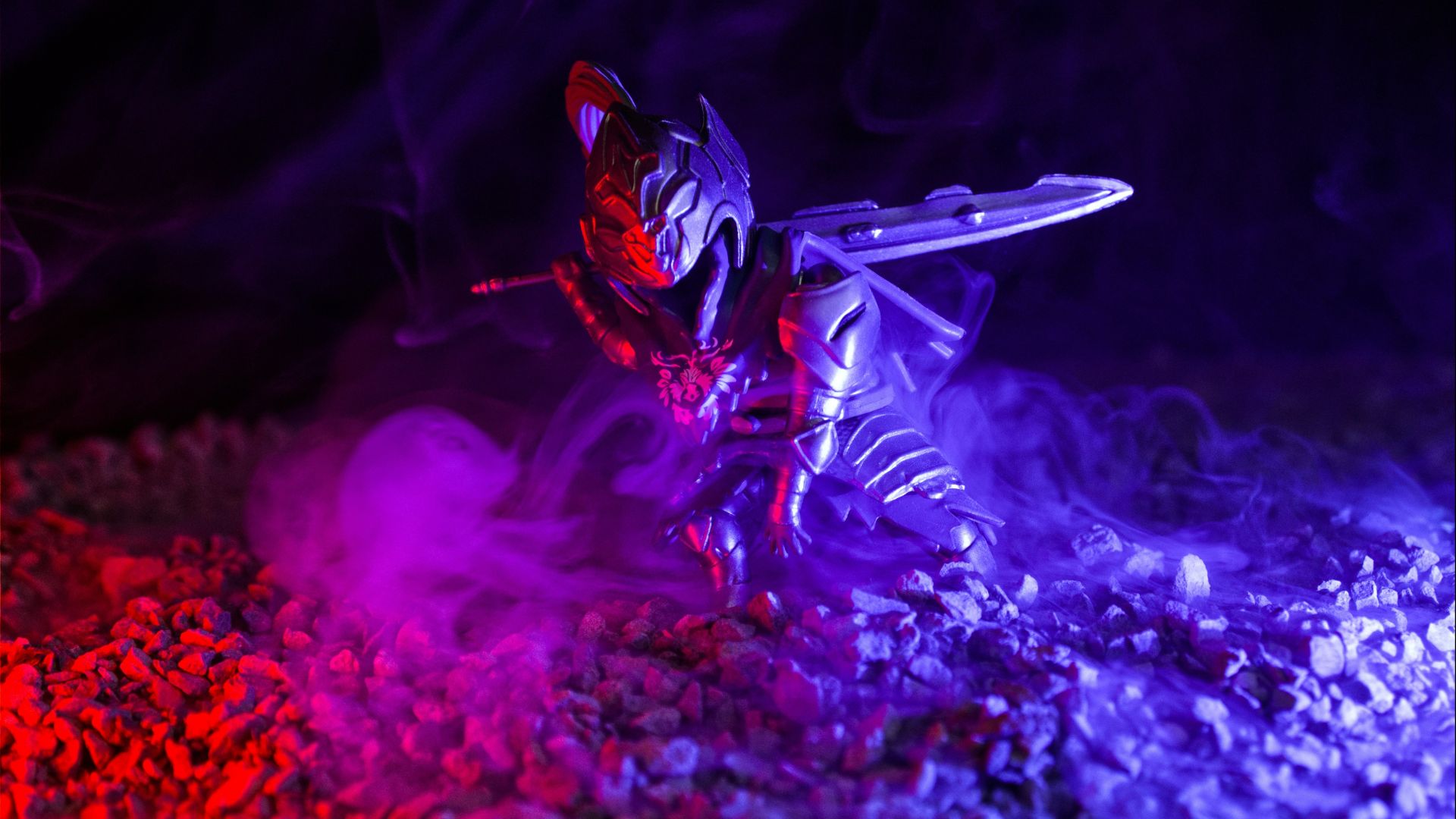 A warrior figure stands amidst red and blue smoke.