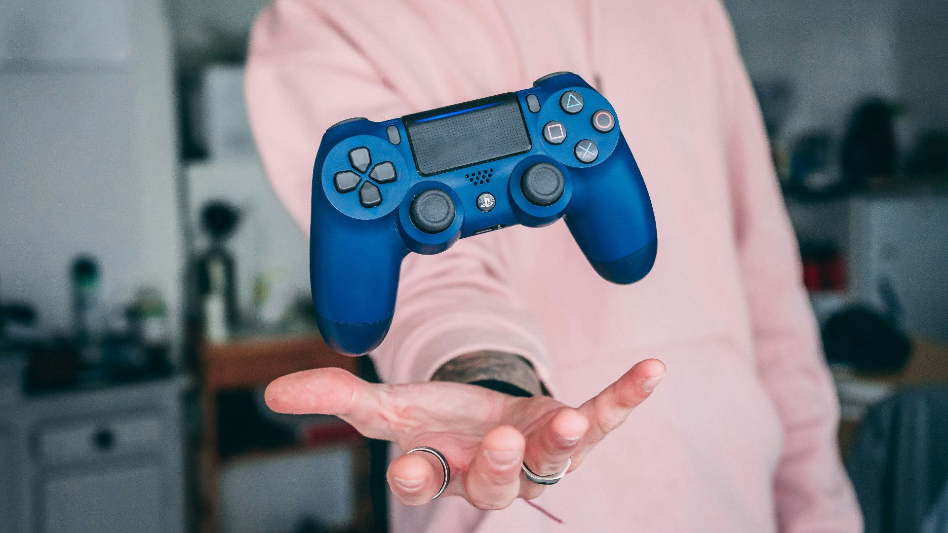 person holding blue Sony PS4 Dualshock 4 c