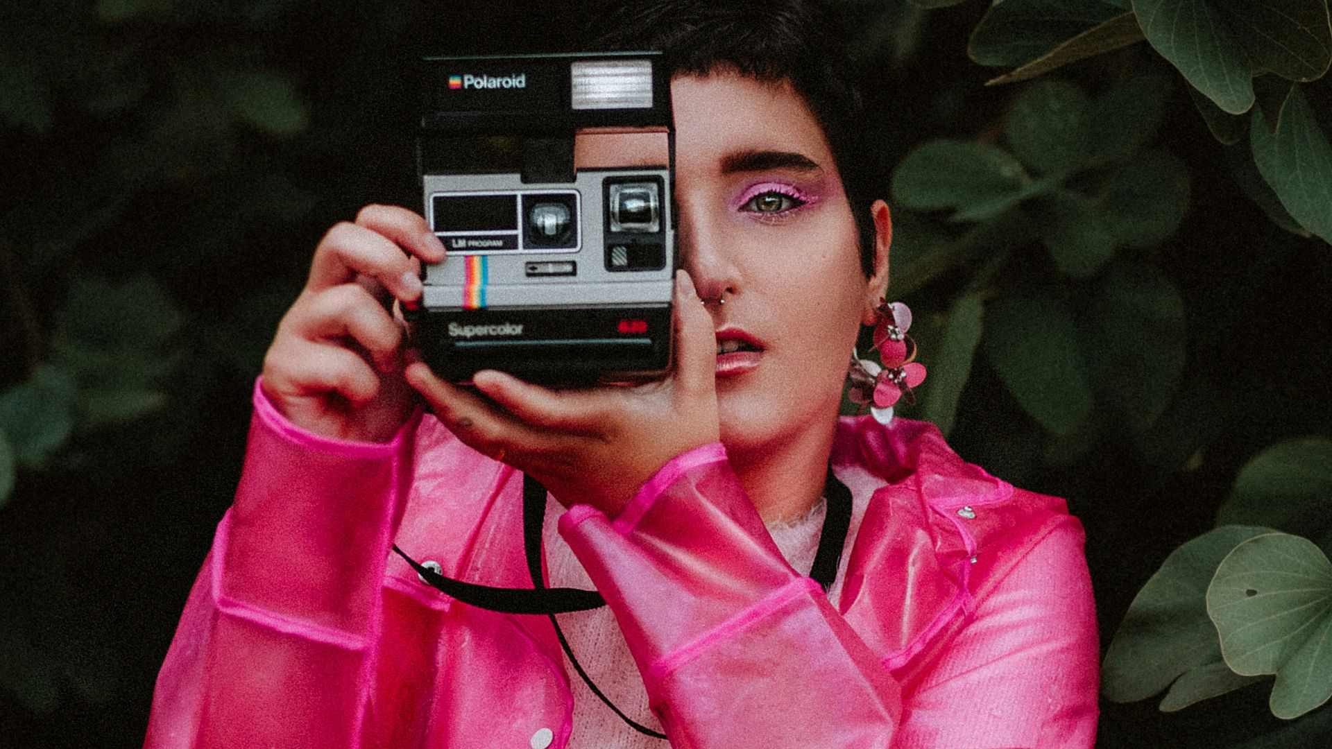 woman in pink jacket holding black and gray camera