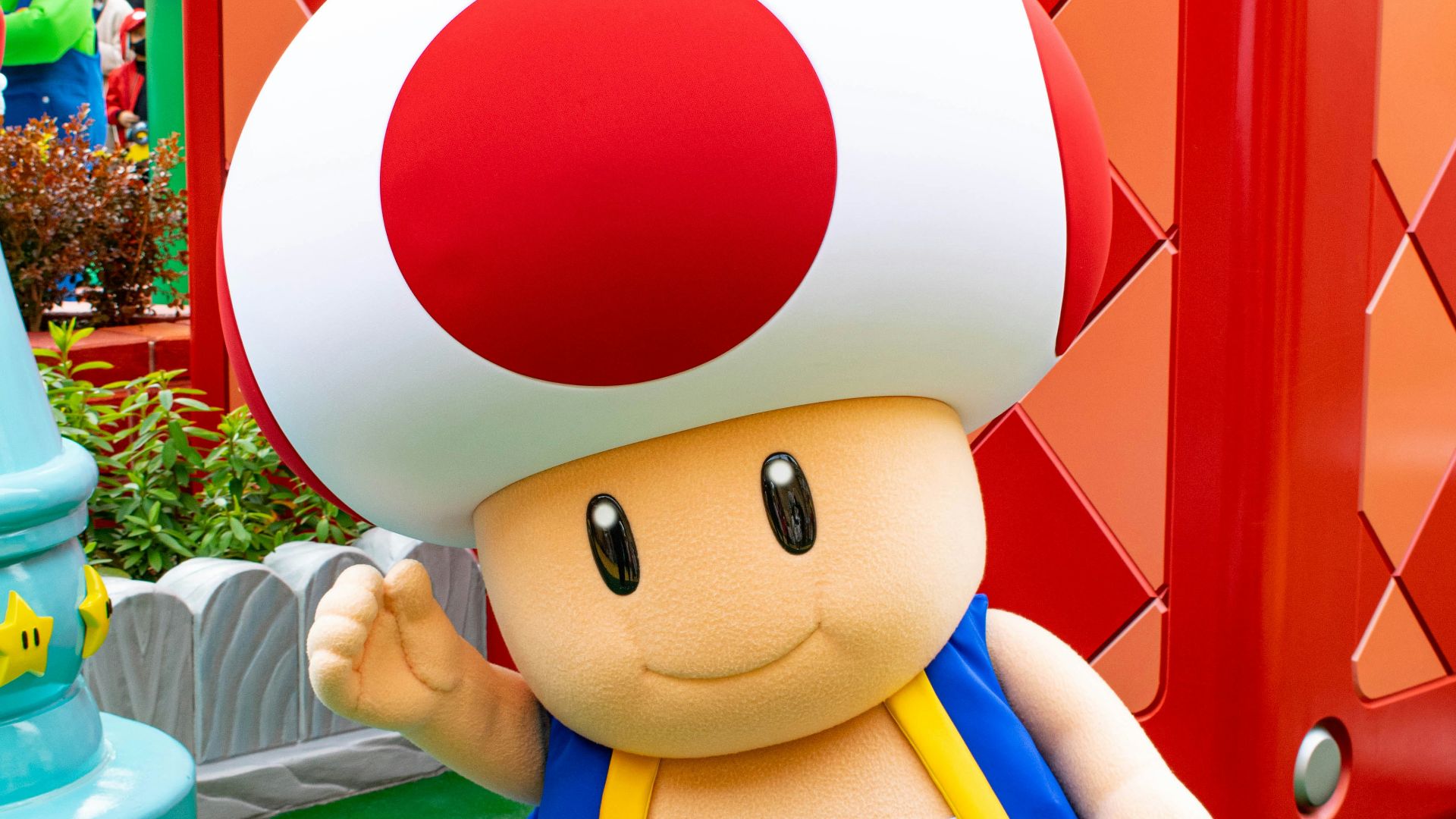 boy in blue and white shirt holding red and white balloon