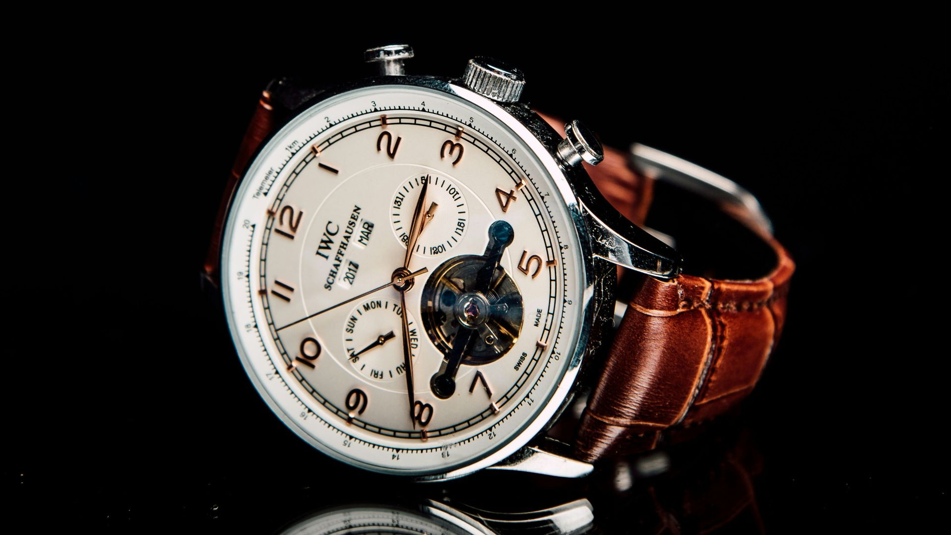 round silver-colored chronograph watch with brown leather strap