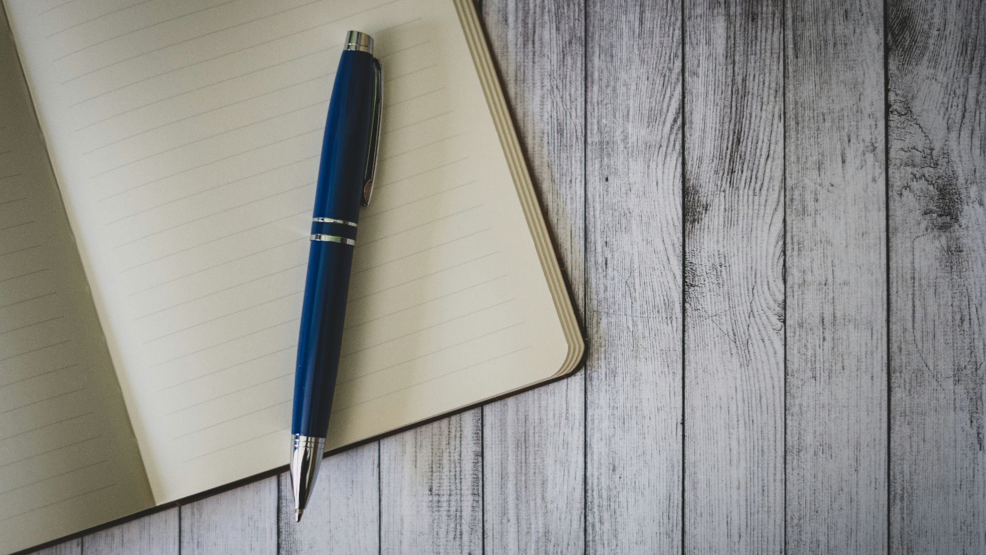 blue click pen on brown wooden table