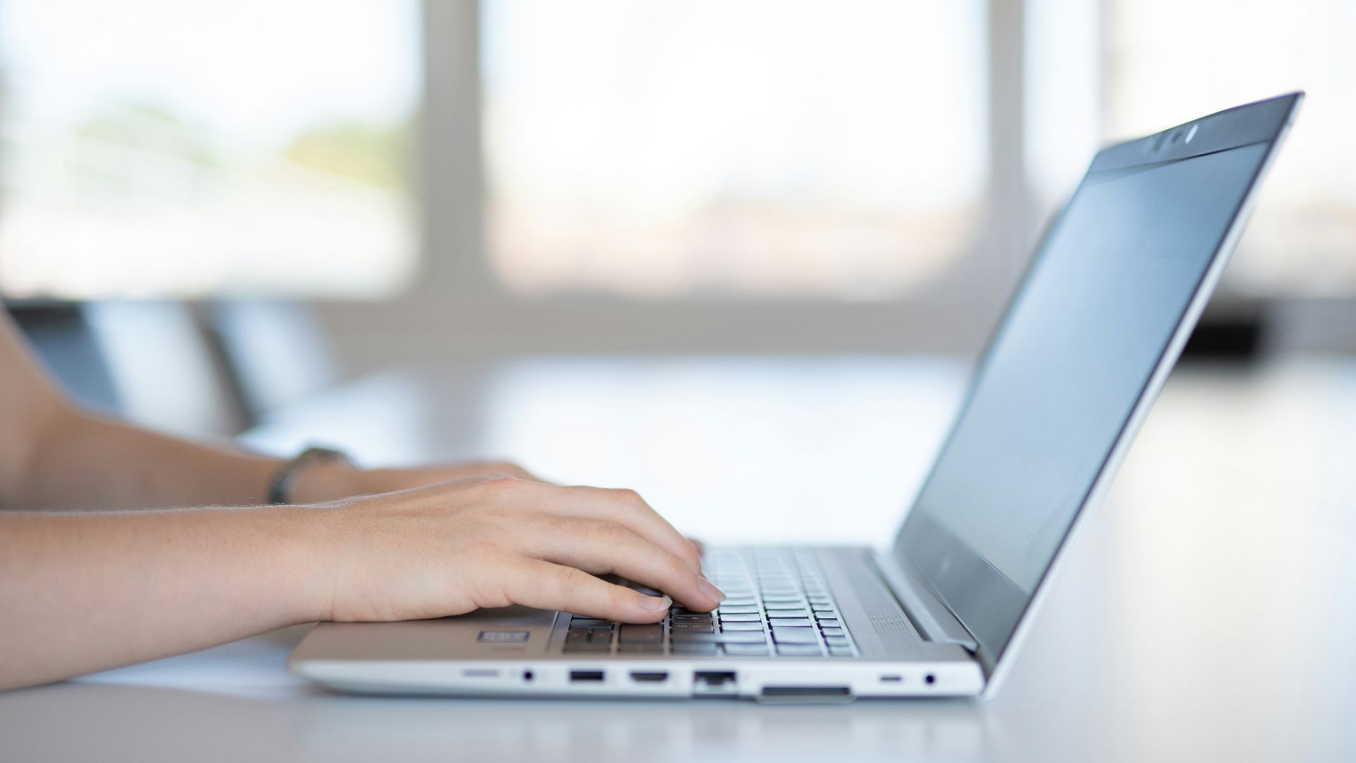 a close up of a person typing on a laptop