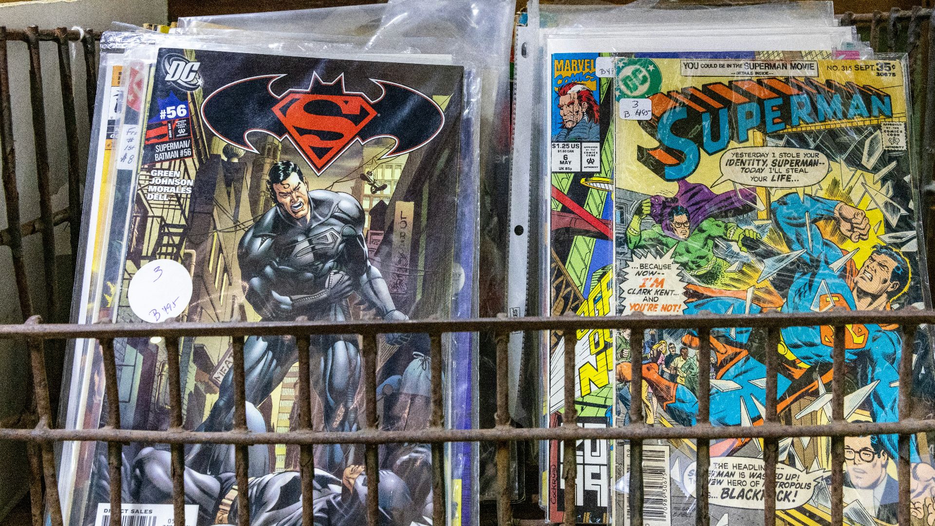 a metal basket filled with comic books on top of a table