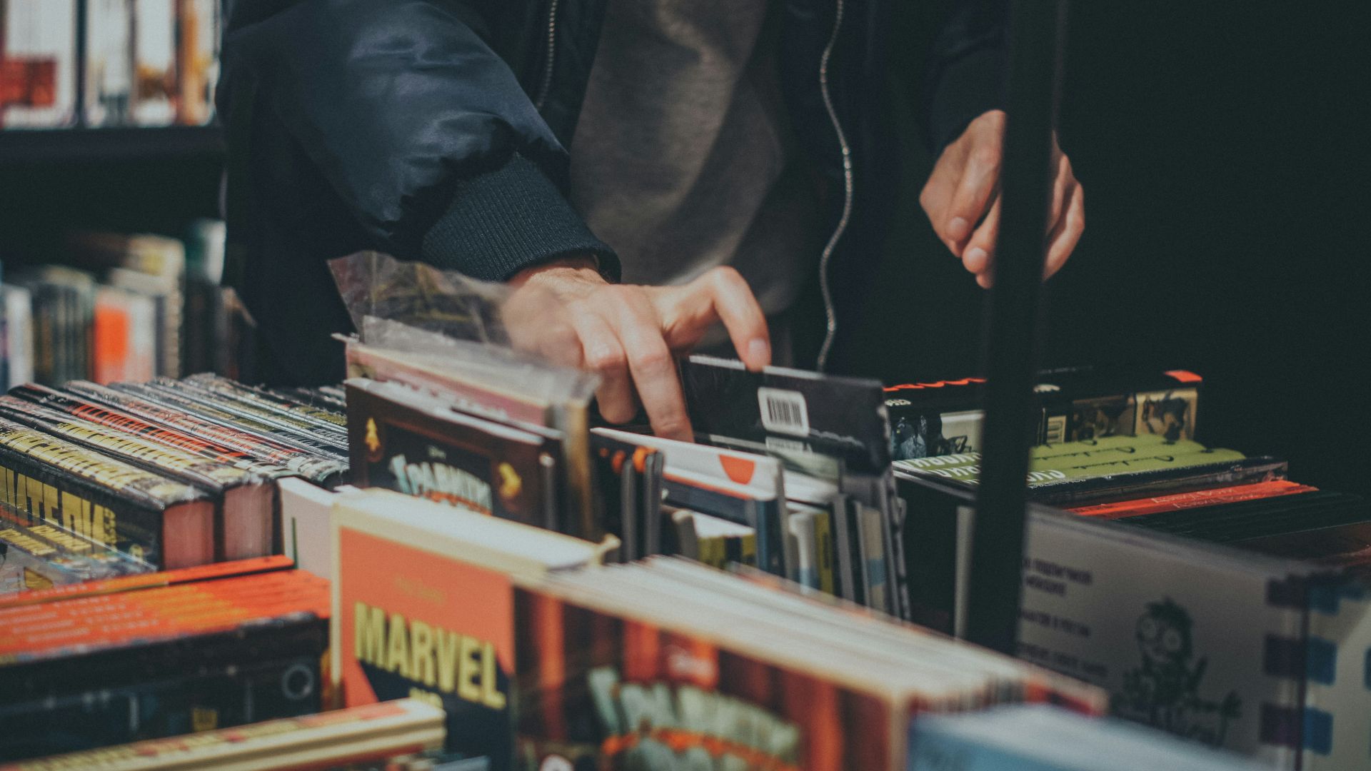 a person picking up a cd from a table