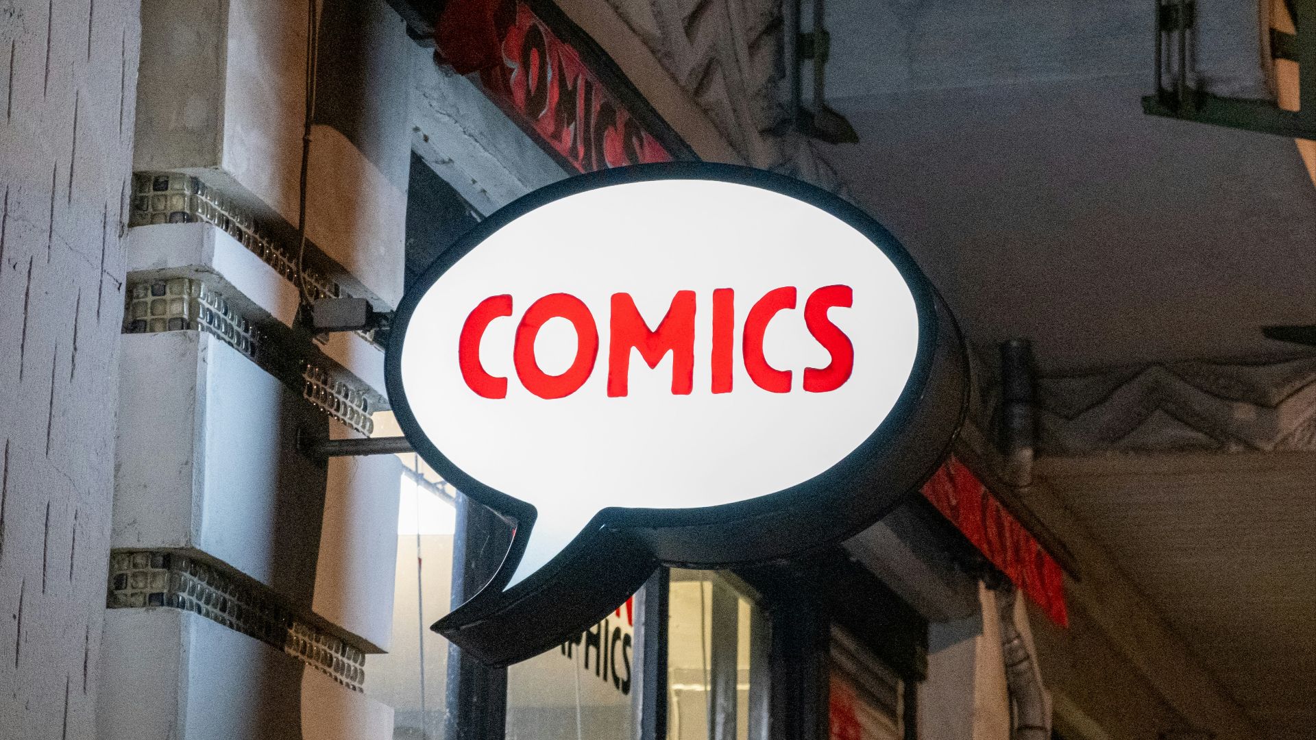a sign that says comics hanging from the side of a building
