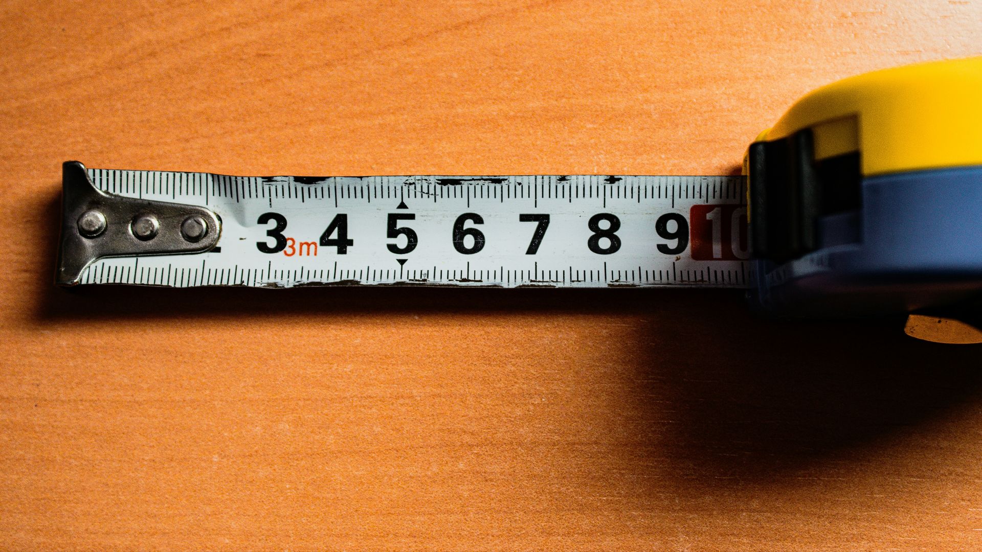 A tape measure is on a wooden table