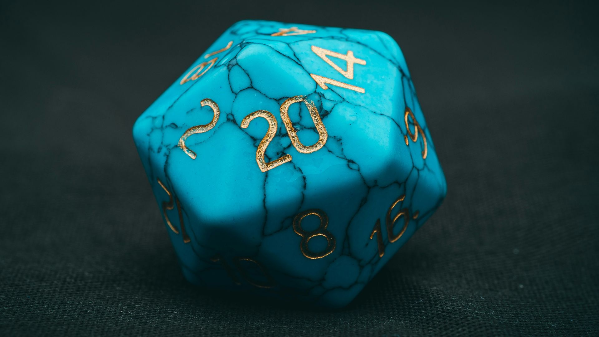 a blue dice with gold numbers on it
