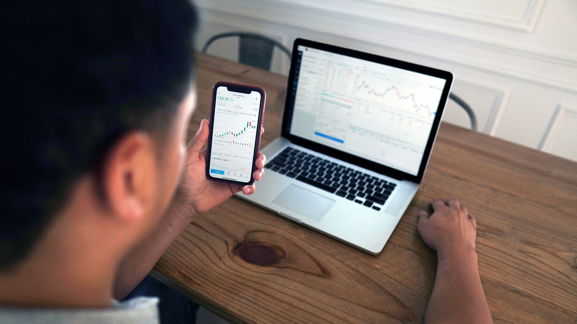 person holding iphone 6 near macbook pro