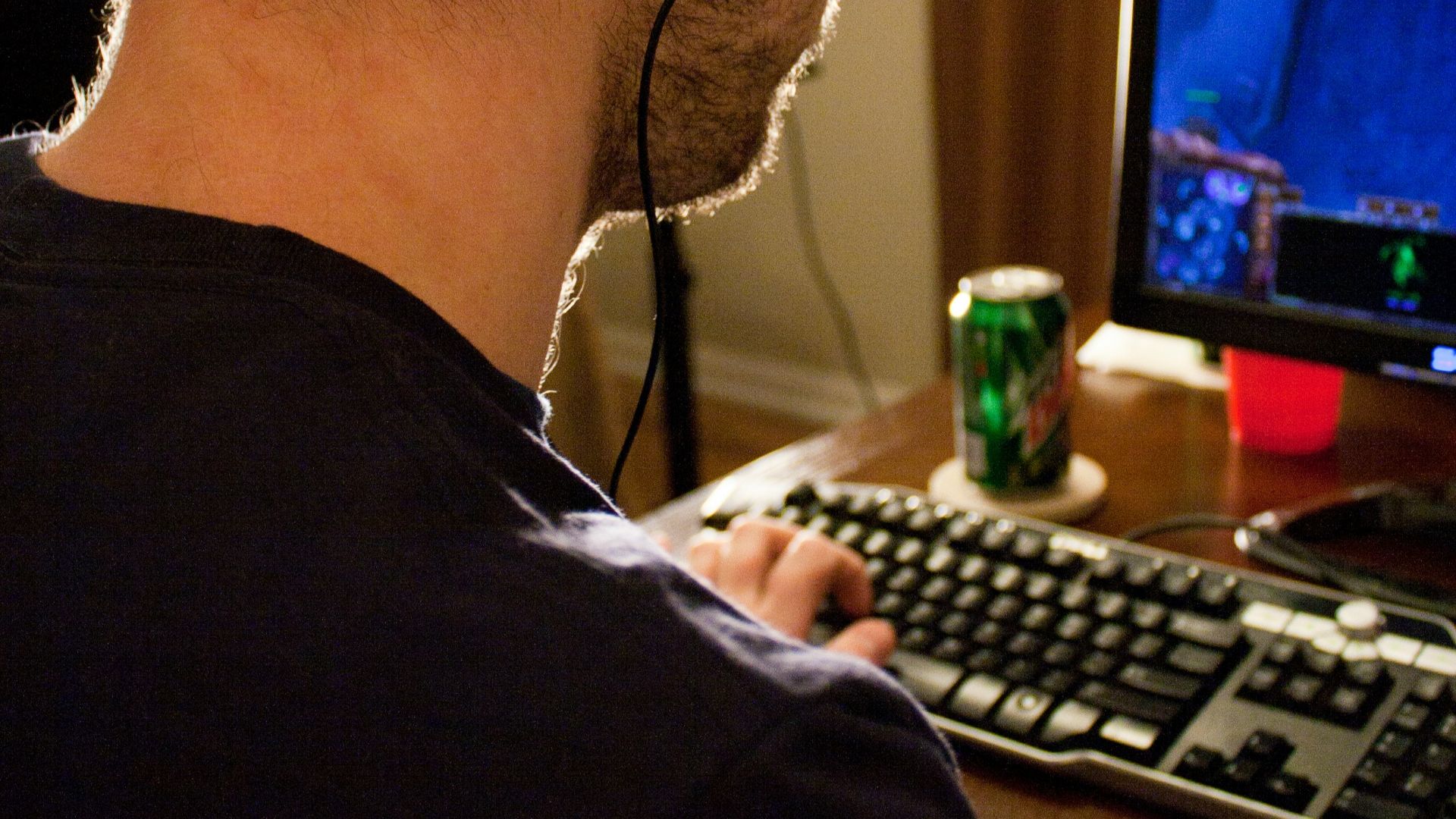 a man sitting in front of a computer with headphones on