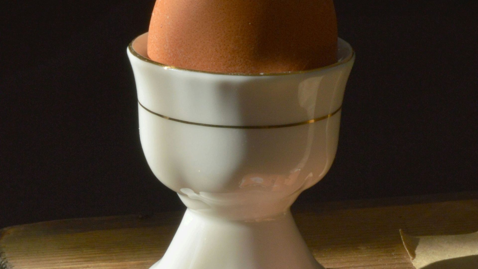 A boiled egg is presented in a cup.