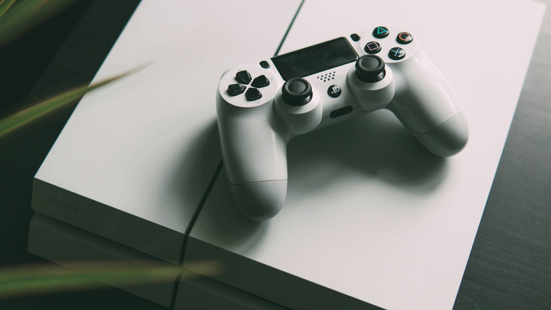 selective focus photography of white Sony PS4 console with wireless controller